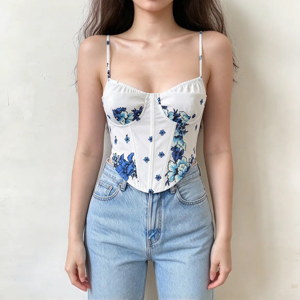 White corset cami top with blue floral print, thin spaghetti straps, sweetheart neckline and curved hem