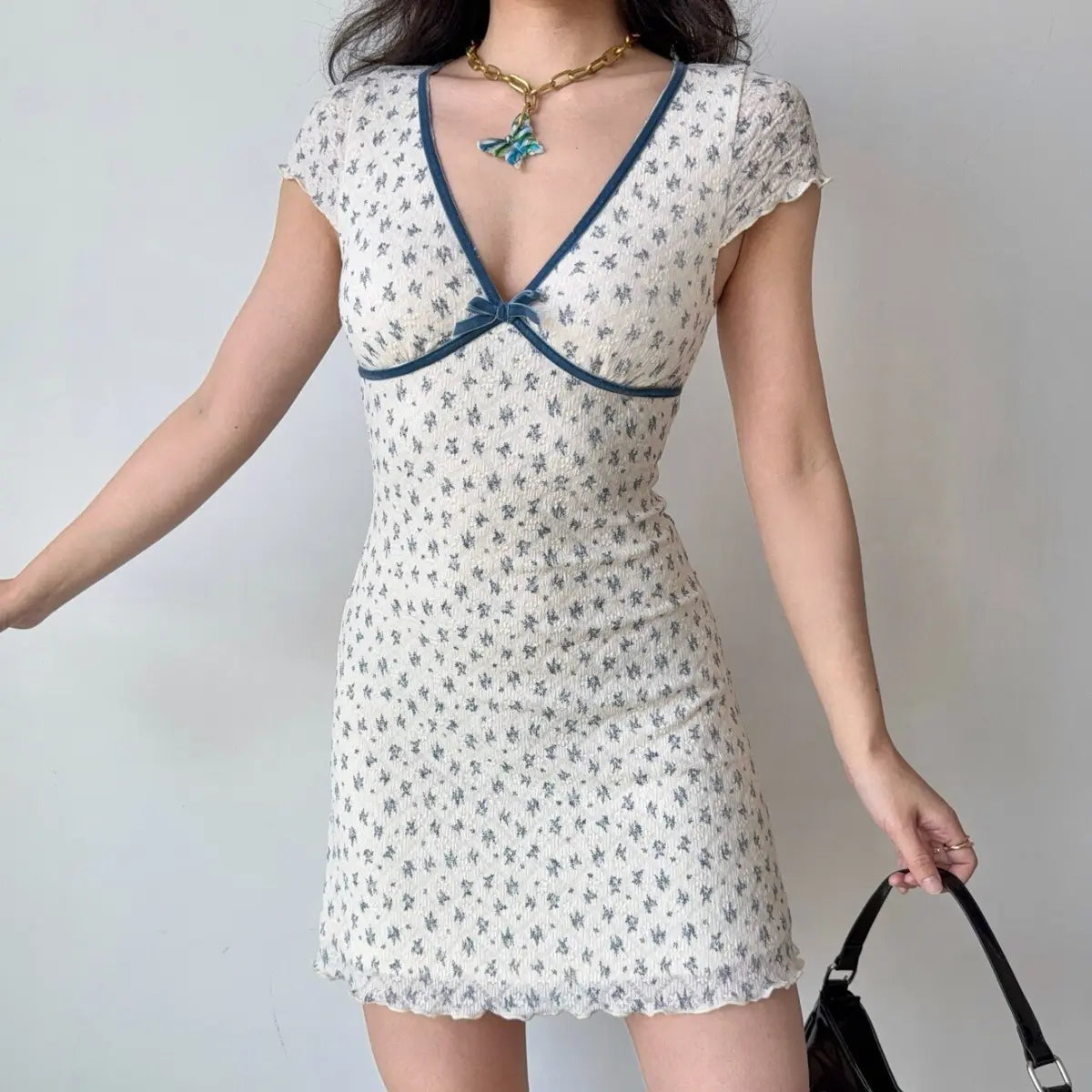 The full look of the white floral mini dress, styled with accessories.