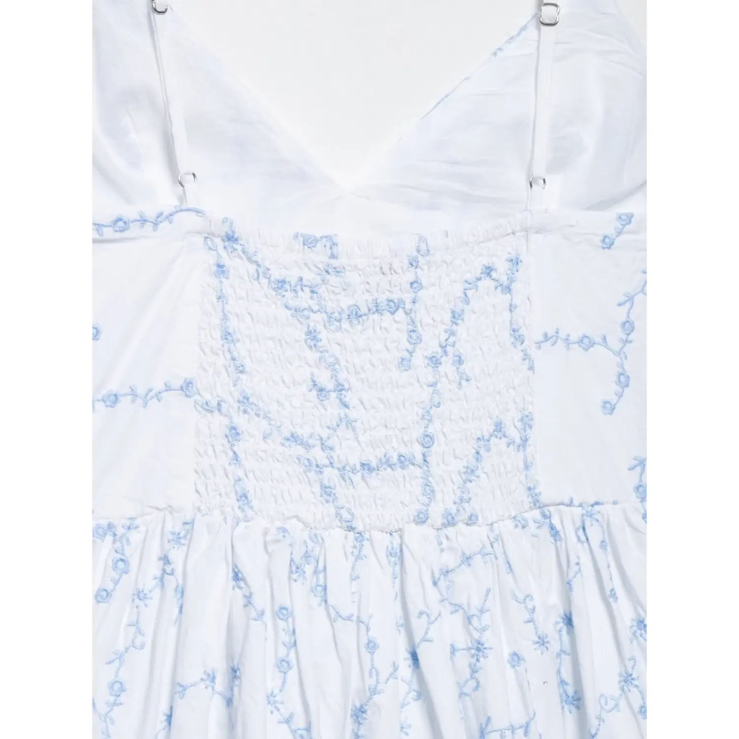 Back smocked elastic bodice close-up white spaghetti strap mini dress with light blue floral vine embroidery