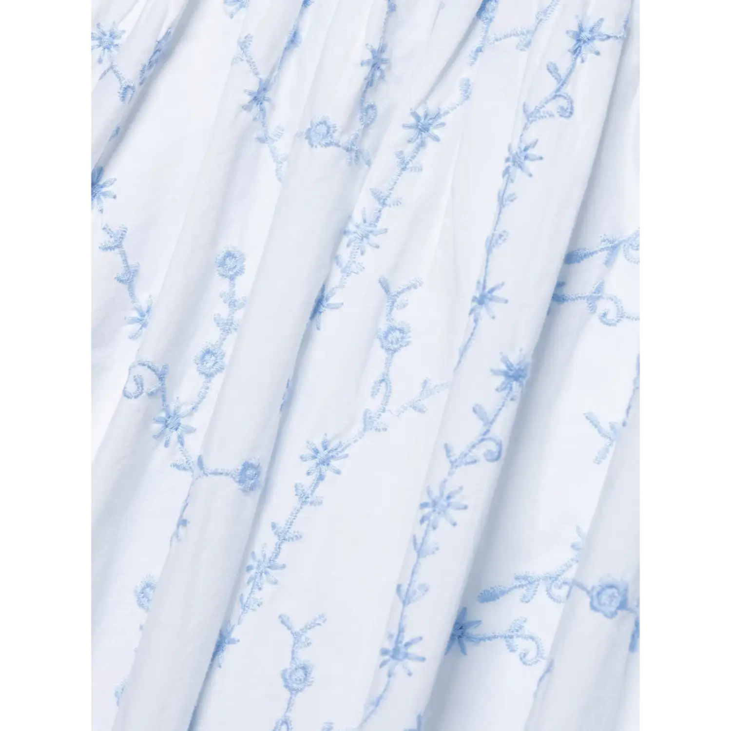 Fabric texture macro shot light blue floral vine embroidery on white cotton dress