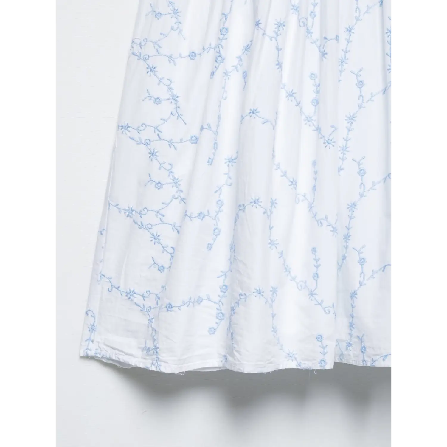 Skirt hem close-up gathered white mini dress with light blue vine floral embroidery