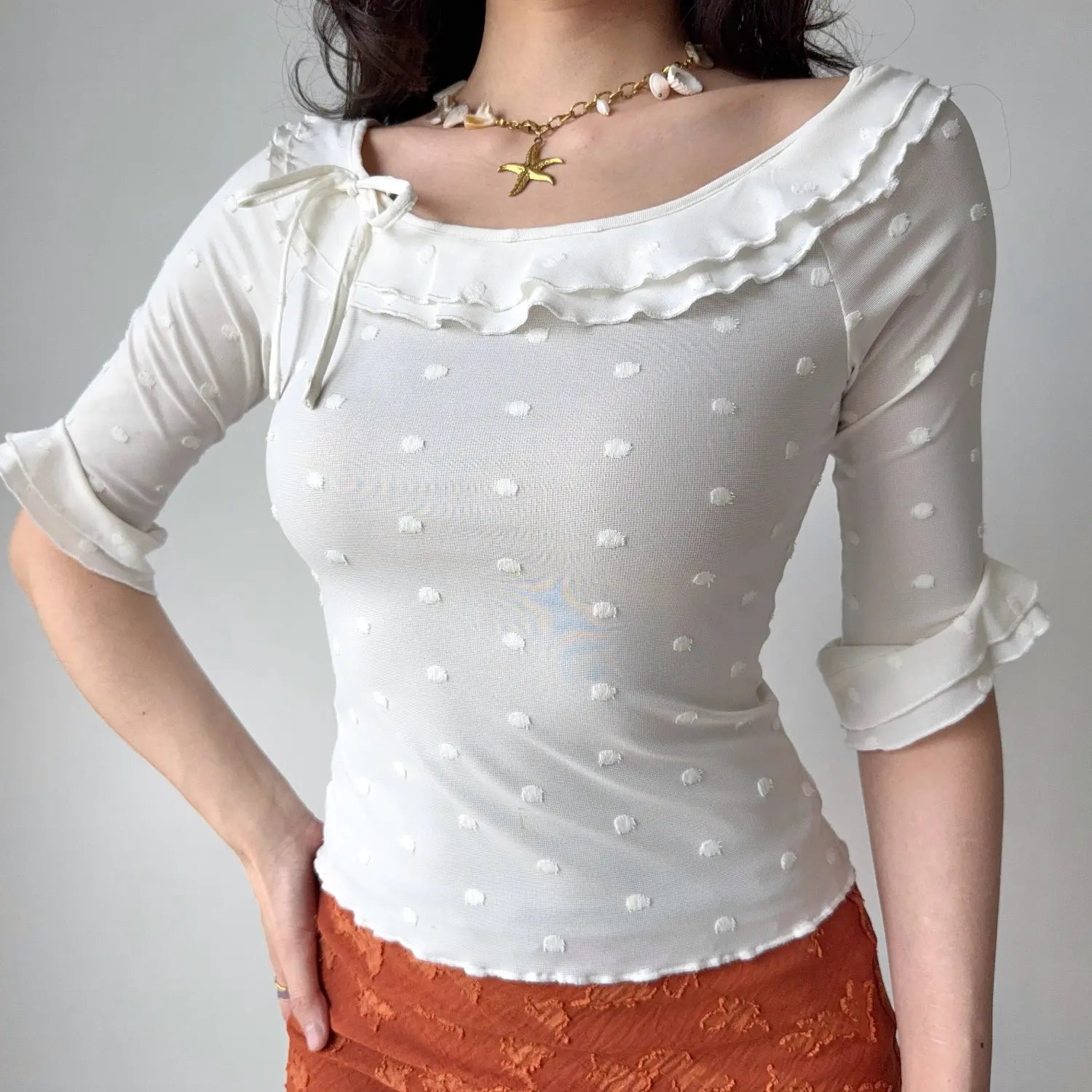 Front full shot of white mesh fitted shirt, wide neck with double ruffle, flared elbow sleeves, everyday casual feminine top