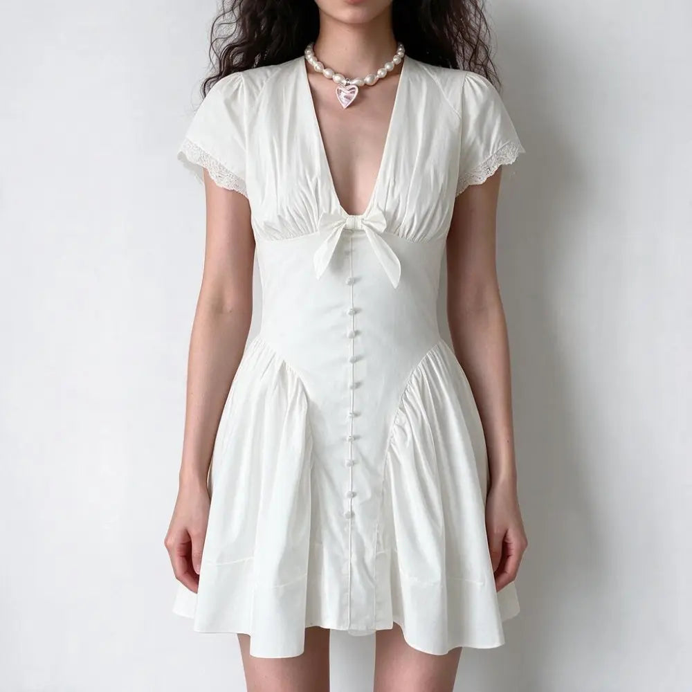 Model wearing white bow v neck lace trim mini dress, front view