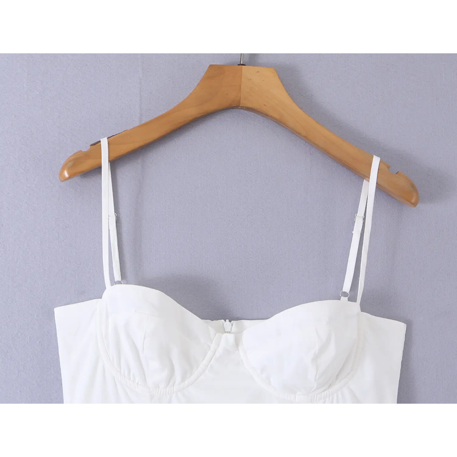 Close-up front view, adjustable thin spaghetti straps, sweetheart molded bust on white mini dress