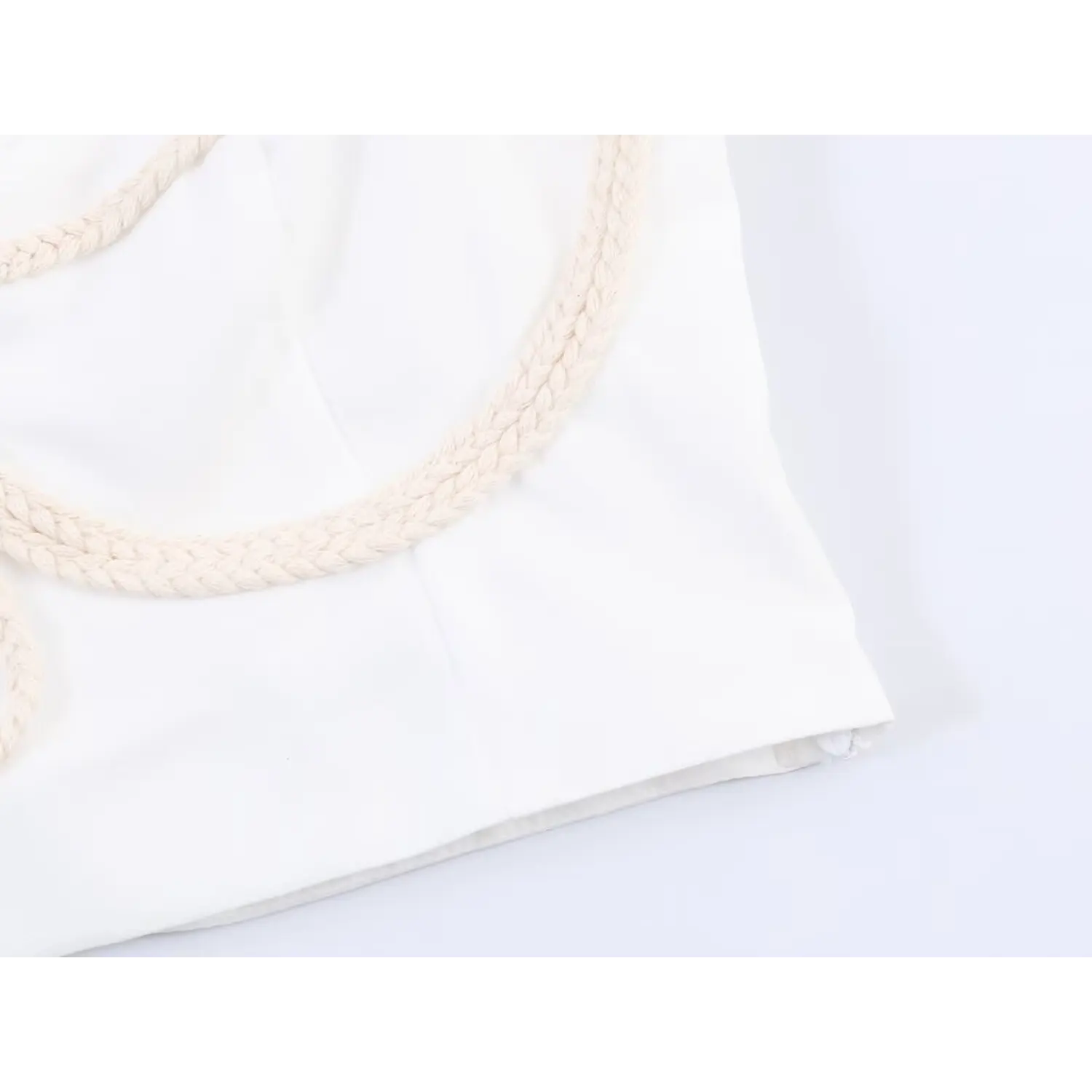 Close-up of side seam and finished hem of white boho cropped camisole top