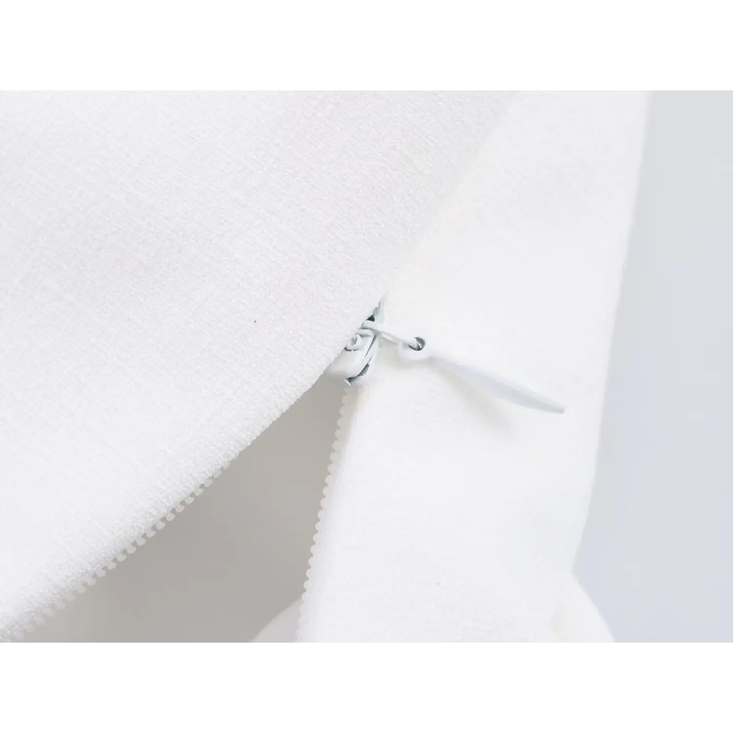 Close-up of invisible side zipper closure on white bohemian crop cami top