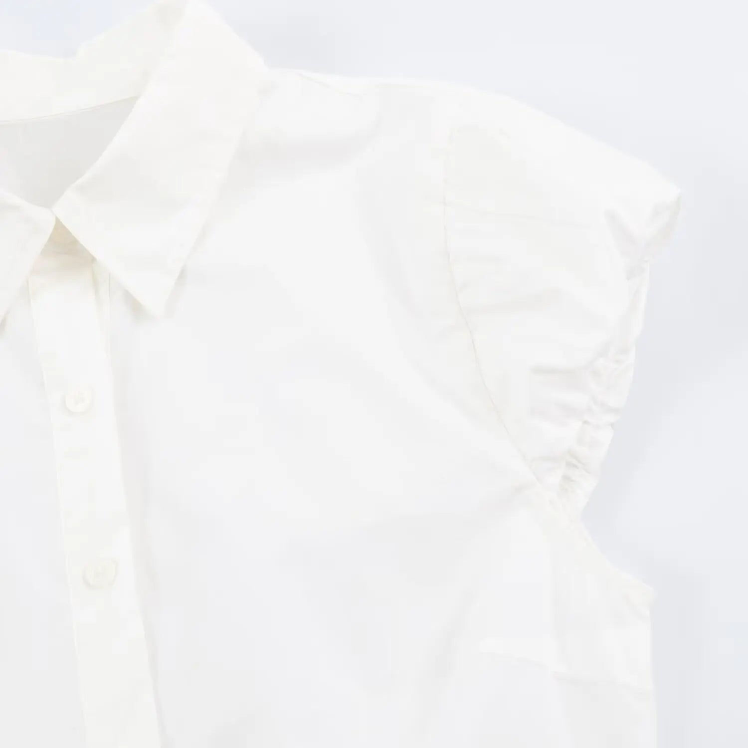 Detail closeup of ruched cap sleeve on white peplum collared blouse