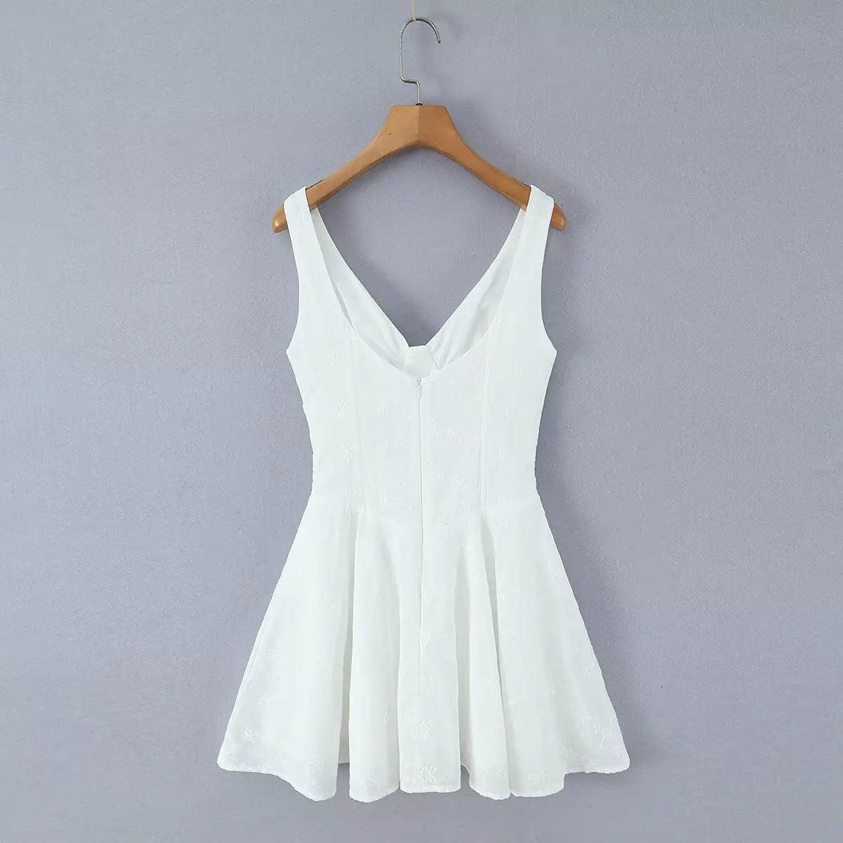 White corset-style cami skater dress hanging on wooden hanger, full back view