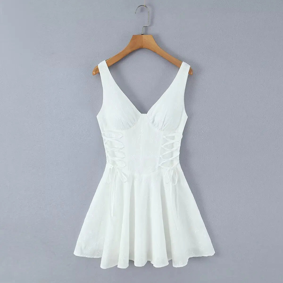 White corset-style cami skater dress hanging on wooden hanger, front view
