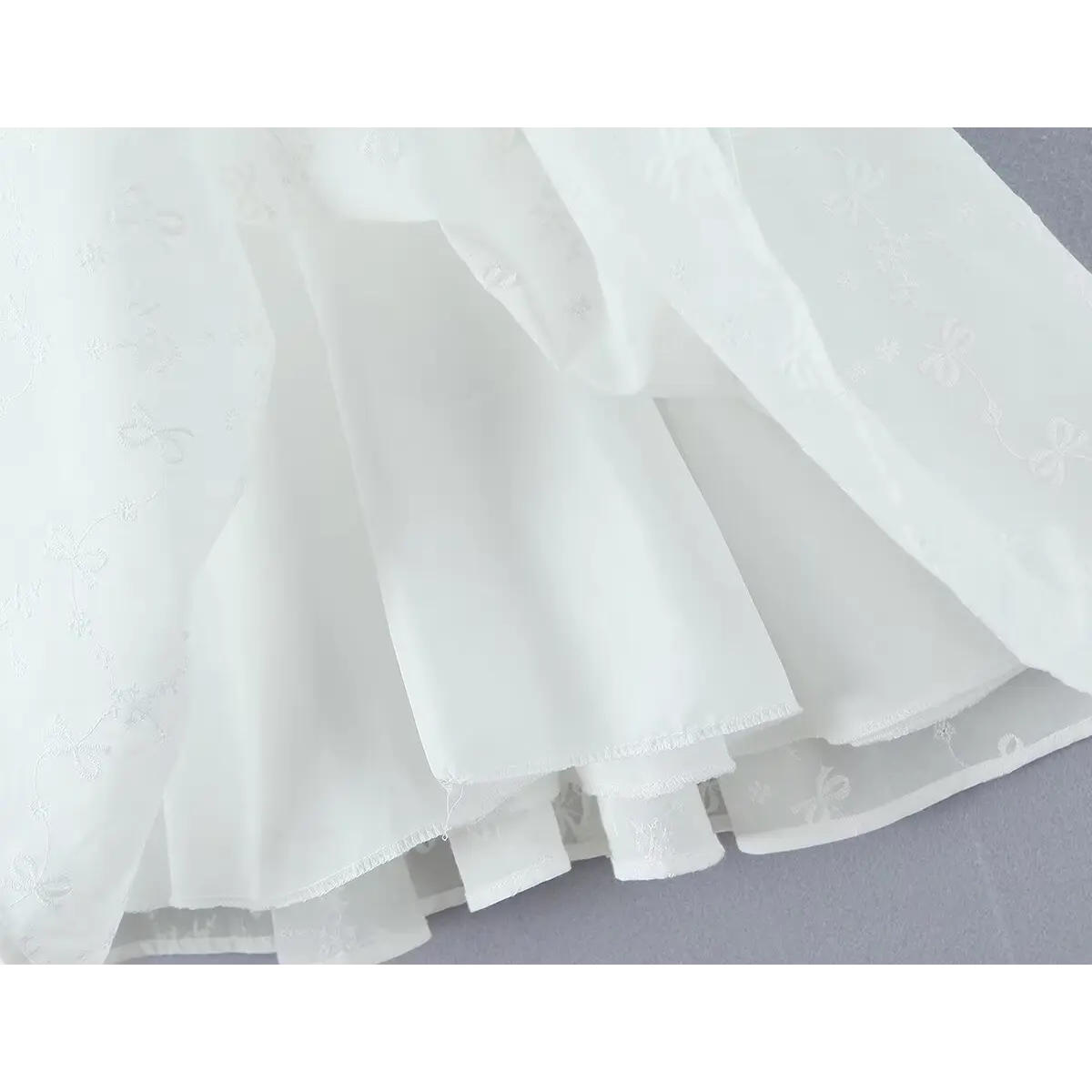 Close-up of the layered skirt and inner lining on the white corset cami dress
