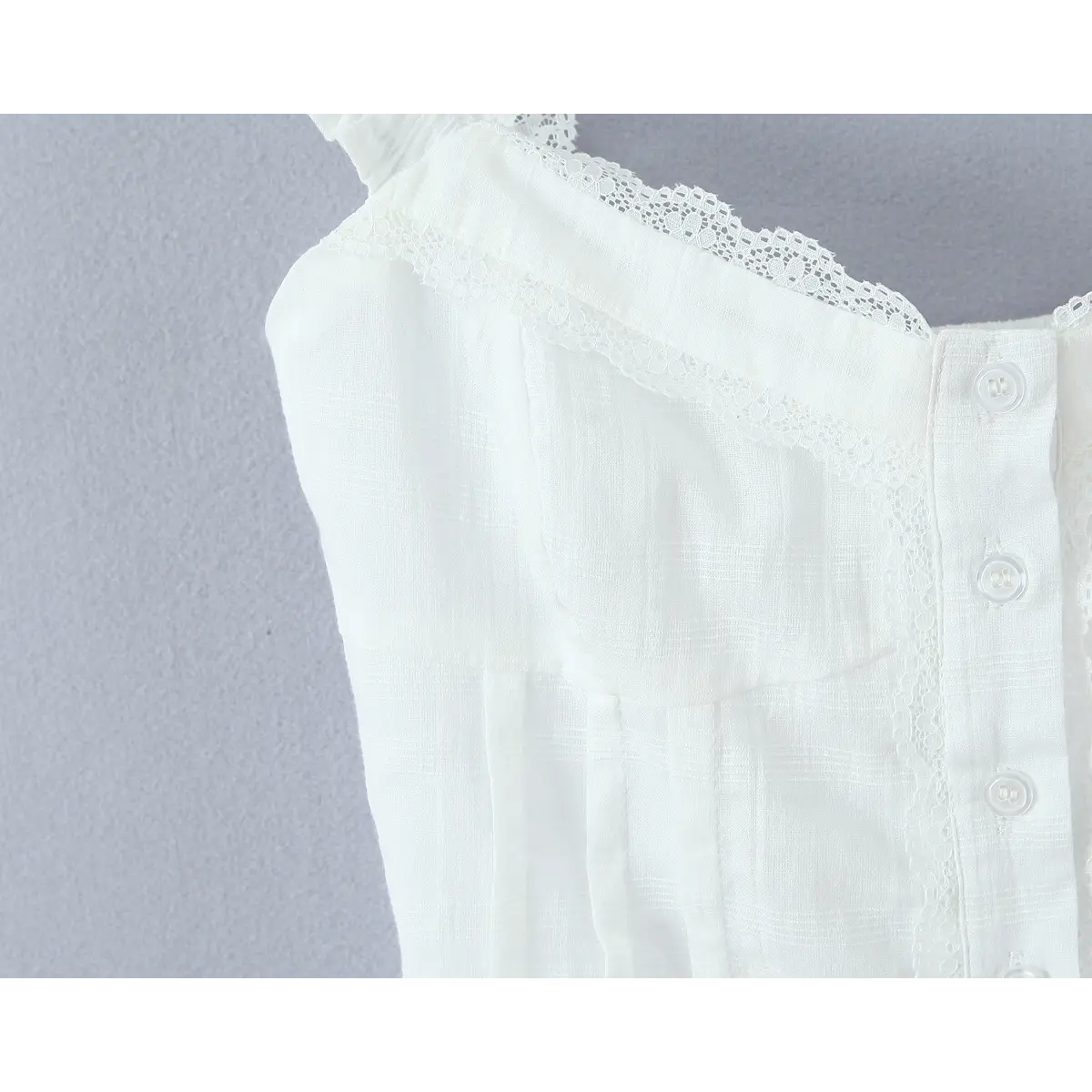 Close-up of the sweetheart neckline, bust darts, and delicate lace trim.