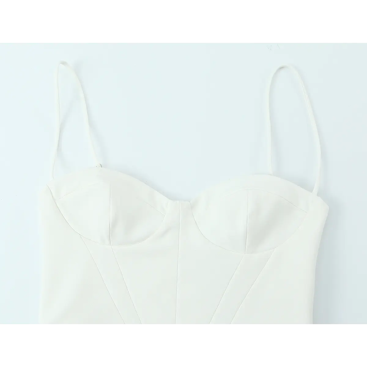 Front view of the white crepe cami dress, showing the bustier-style sweetheart neckline, vertical boning seams, and thin straps