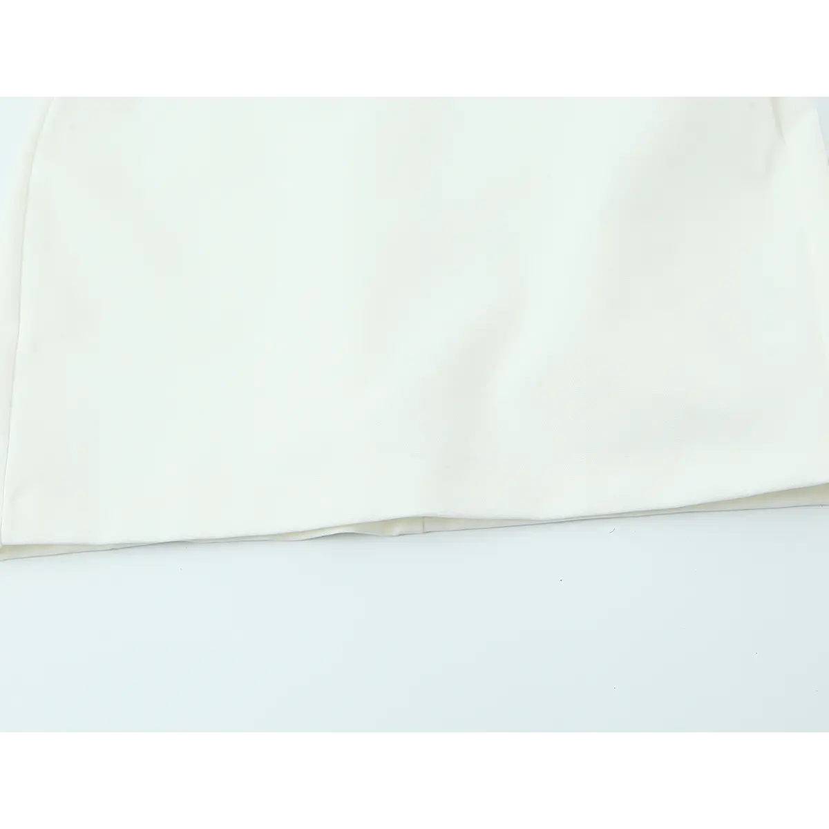 Hem view of the white crepe cami dress, showing the smooth skirt and clean pressed seams