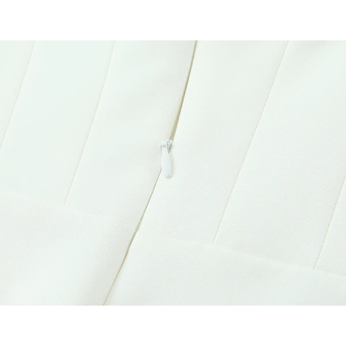 Close-up of the center back zipper on the white crepe dress, showing the matching white pull and vertical boning seams