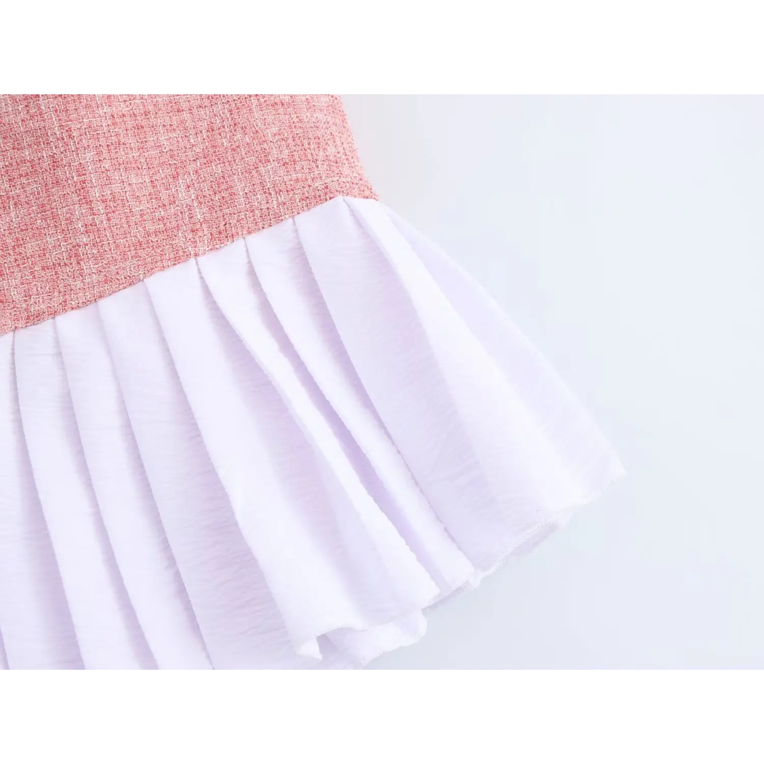 Lower skirt full panel, evenly spaced crisp vertical pleats, lightweight wavy crepe fabric contrast heavy tweed upper