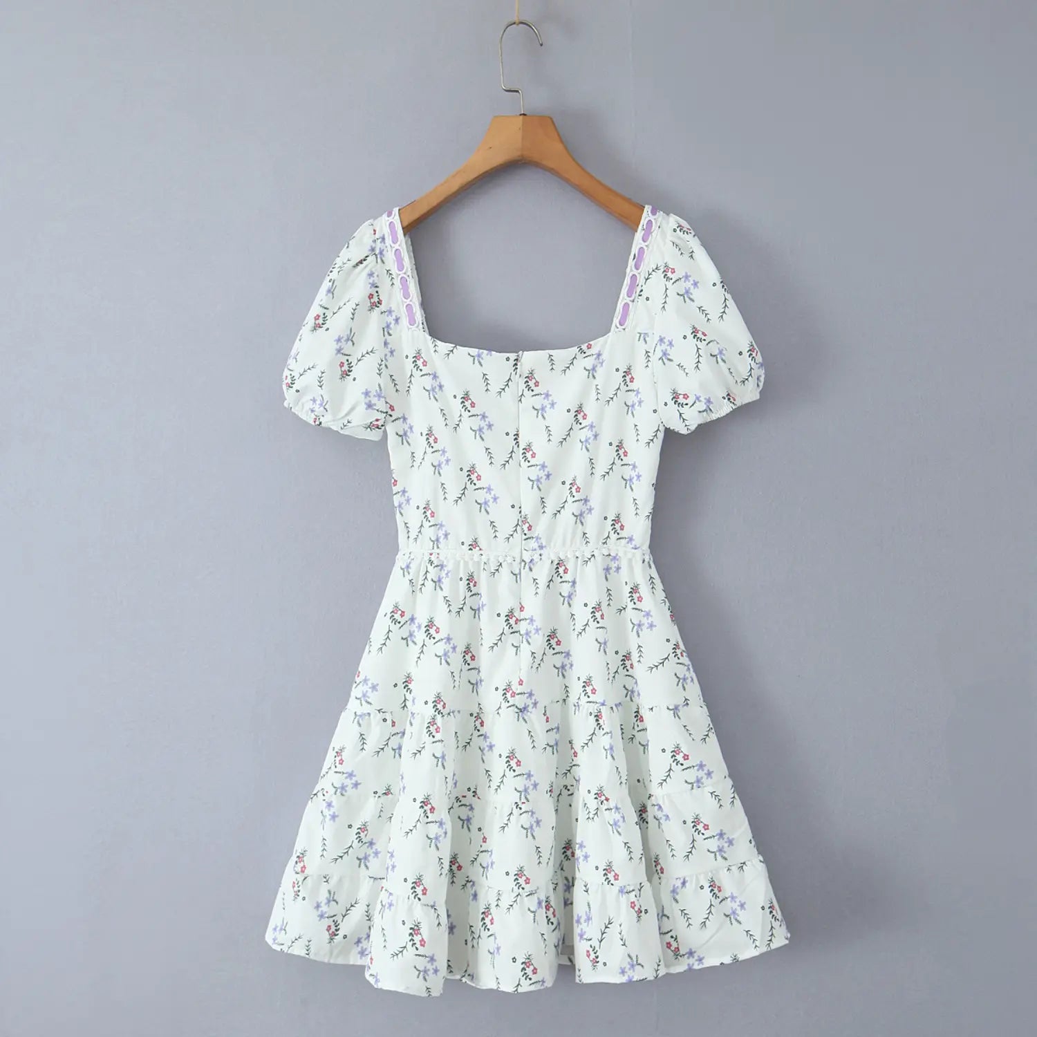 Full hanging product shot of women white ditsy floral mini dress, square neck puff sleeve, purple ribbon decor, tiered ruffle skirt