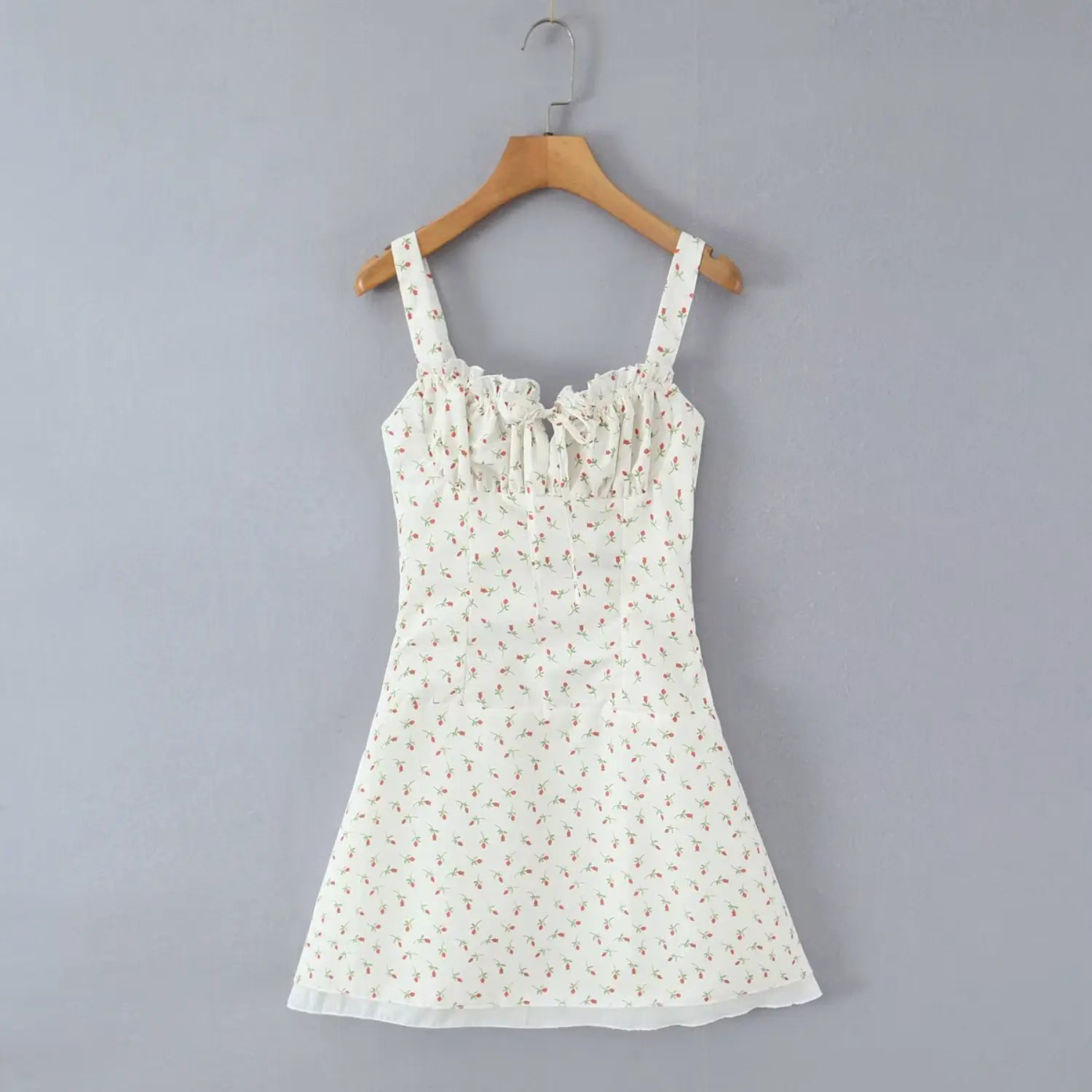 Full front hanging shot wooden hanger white floral cami mini dress ruffle square neck tie detail a‑line skirt grey background