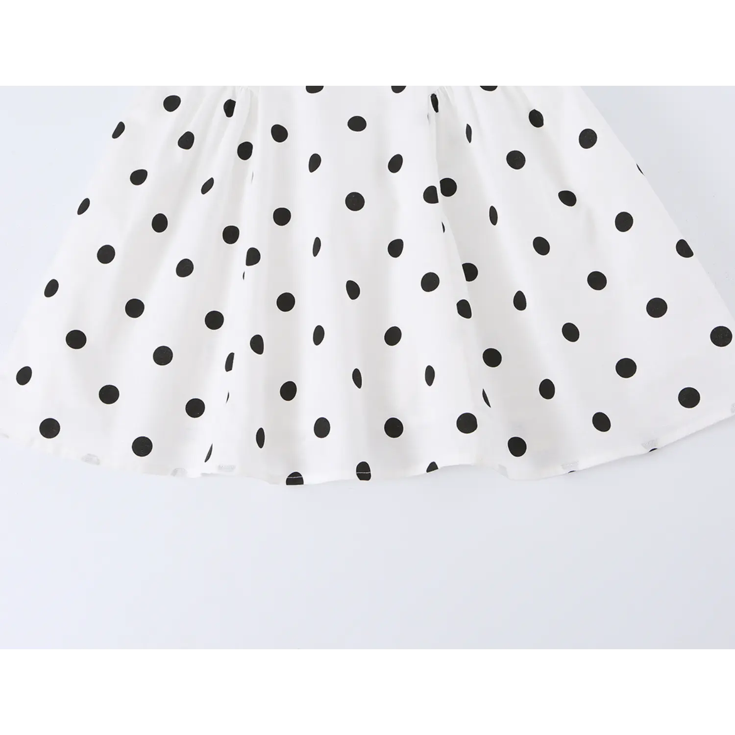 White black polka dot mini dress skirt hem macro shot, a-line flared drape woven dot fabric stitching flat lay detail