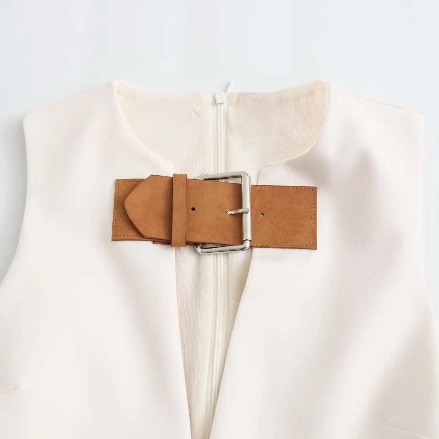 Close‑up of brown faux leather wide buckle with silver metal hardware on dress neckline