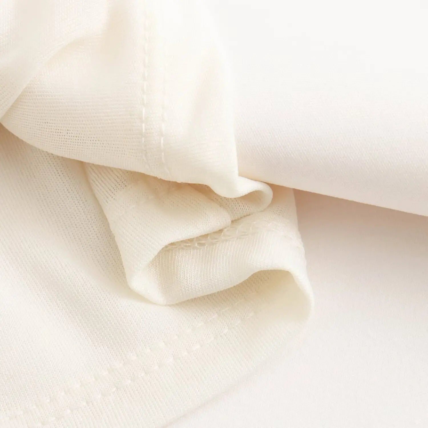 Close‑up inner lining fabric and fine overlock seam workmanship of white mini dress