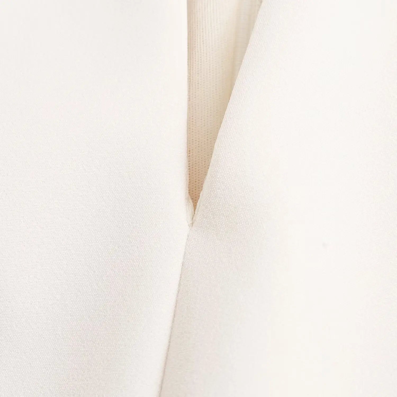 Close‑up front keyhole cutout fabric texture and clean seam finish on white sleeveless dress