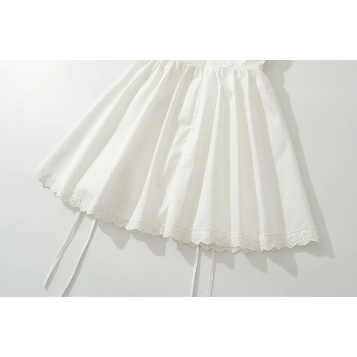 White mini dress flared skirt with scalloped lace hem and side drawstring ties