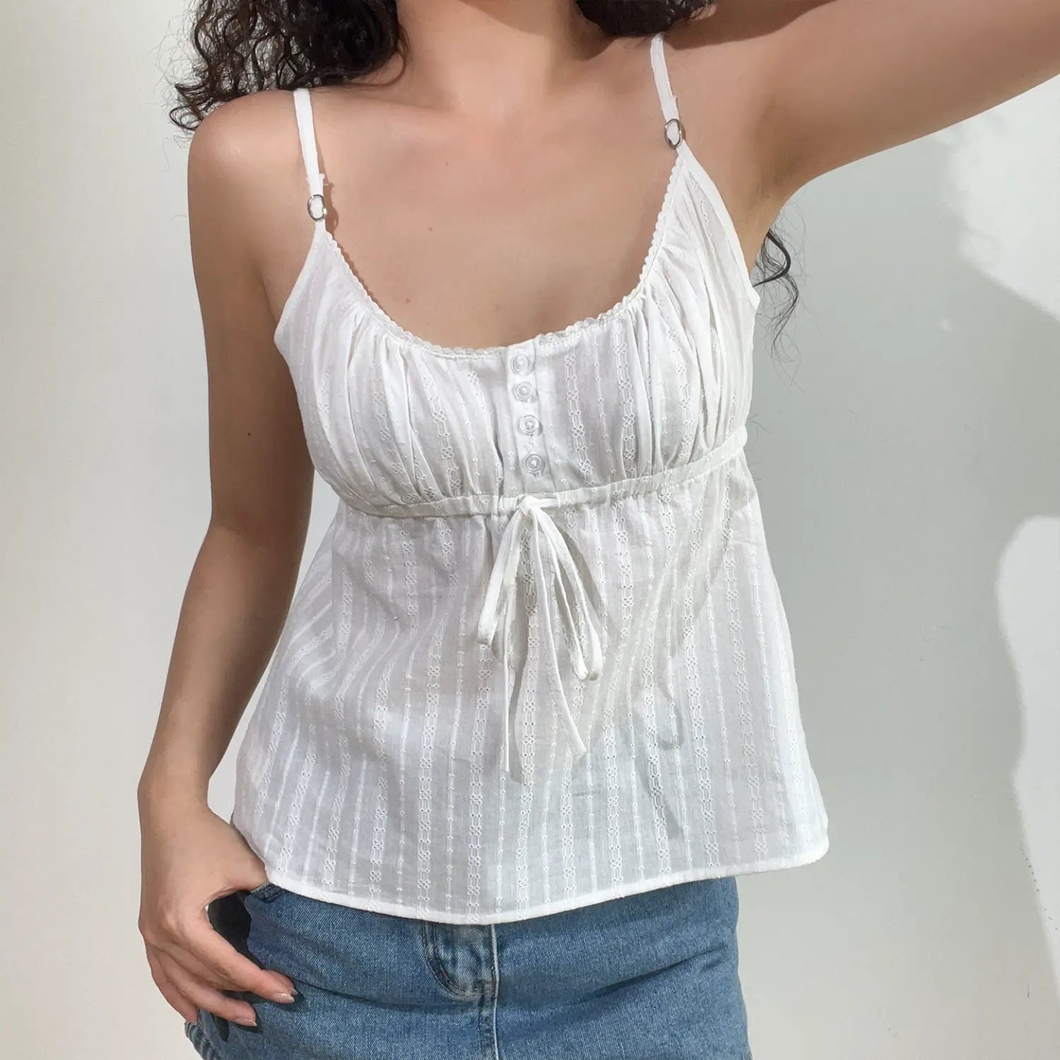Close-up shot of white textured cami top, highlighting the fabric pattern and front buttons