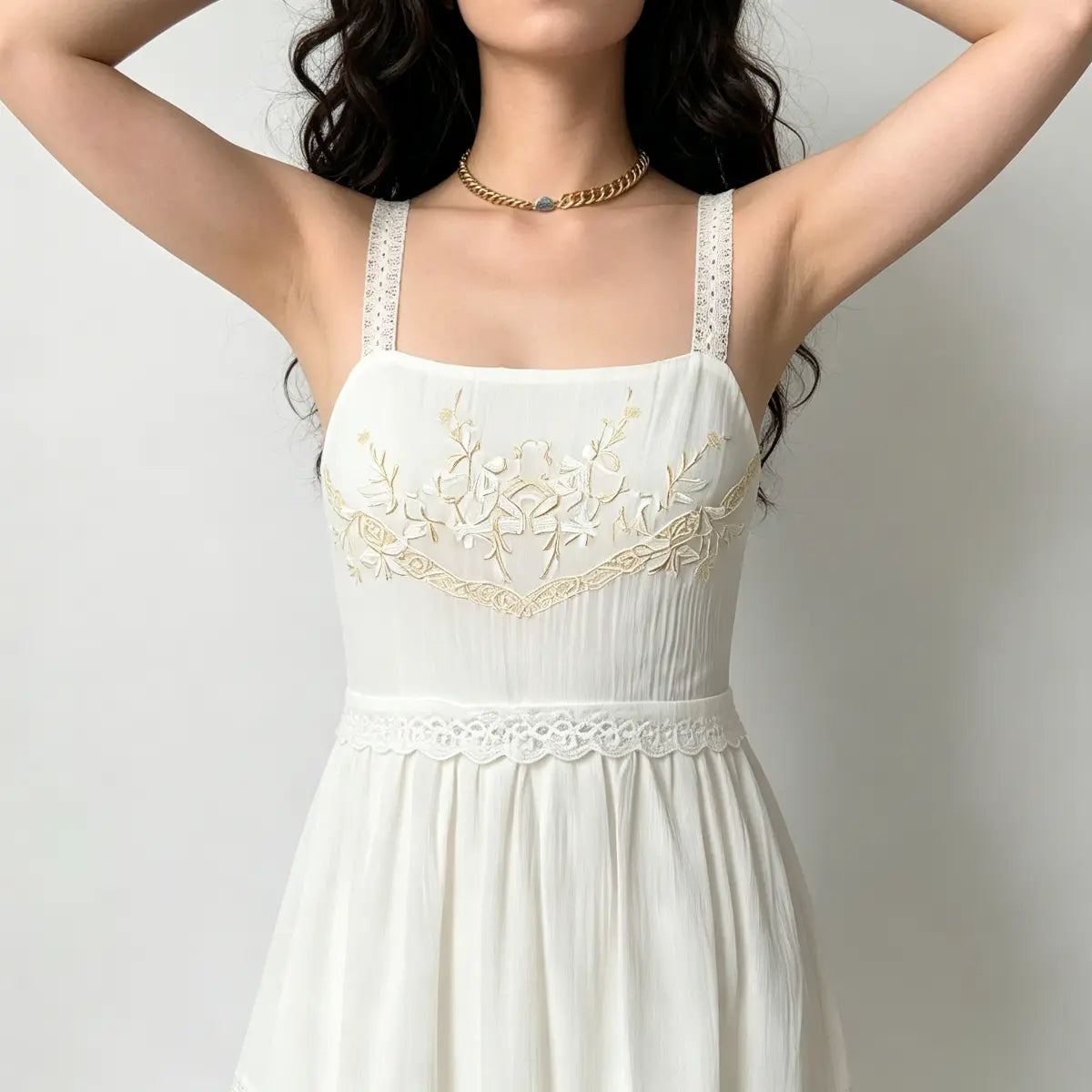 Close up shot of exquisite floral embroidery and fine lace craft on classic white cami dress fabric.