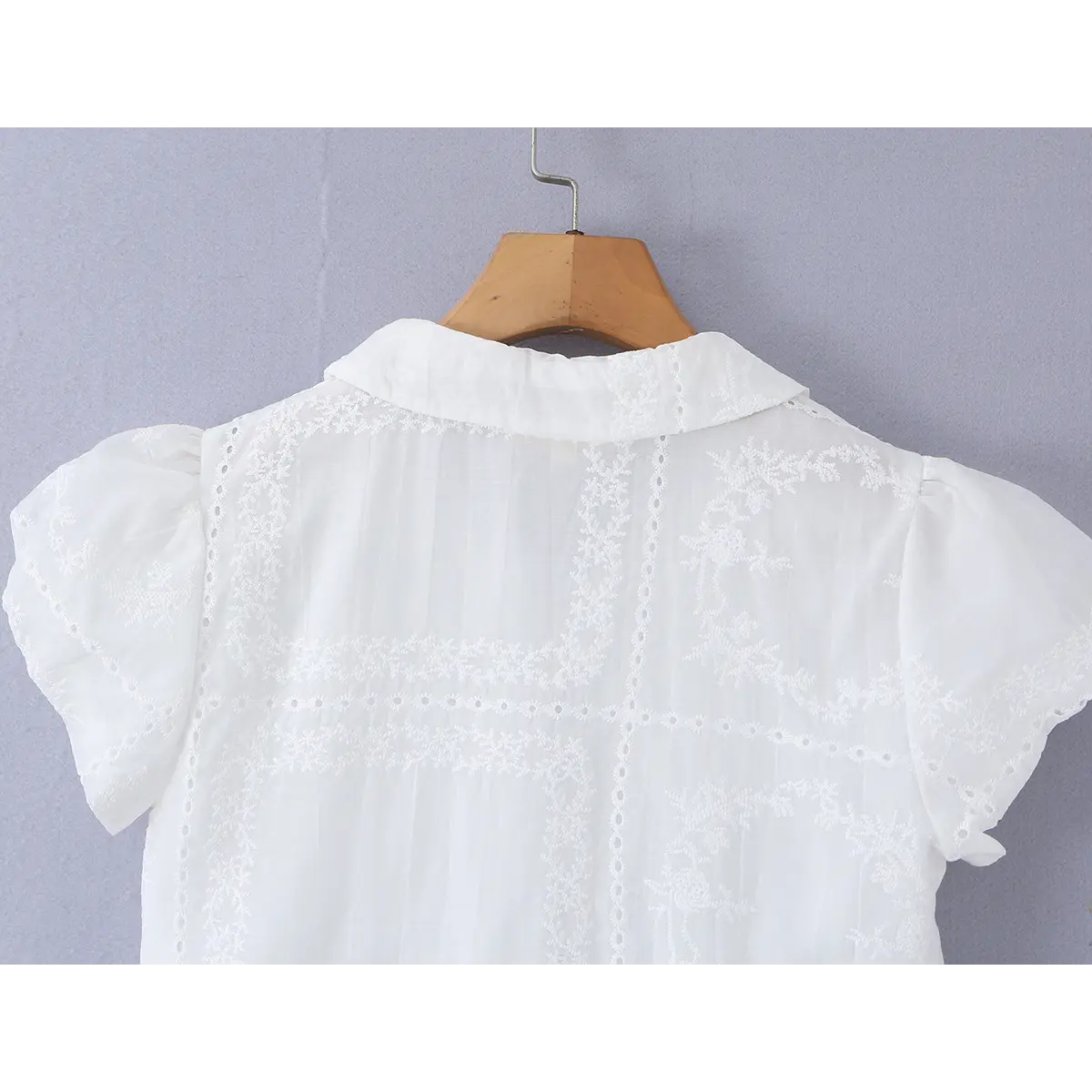 Close-up of the back view, showing the Peter Pan collar and puff sleeves with matching embroidery.