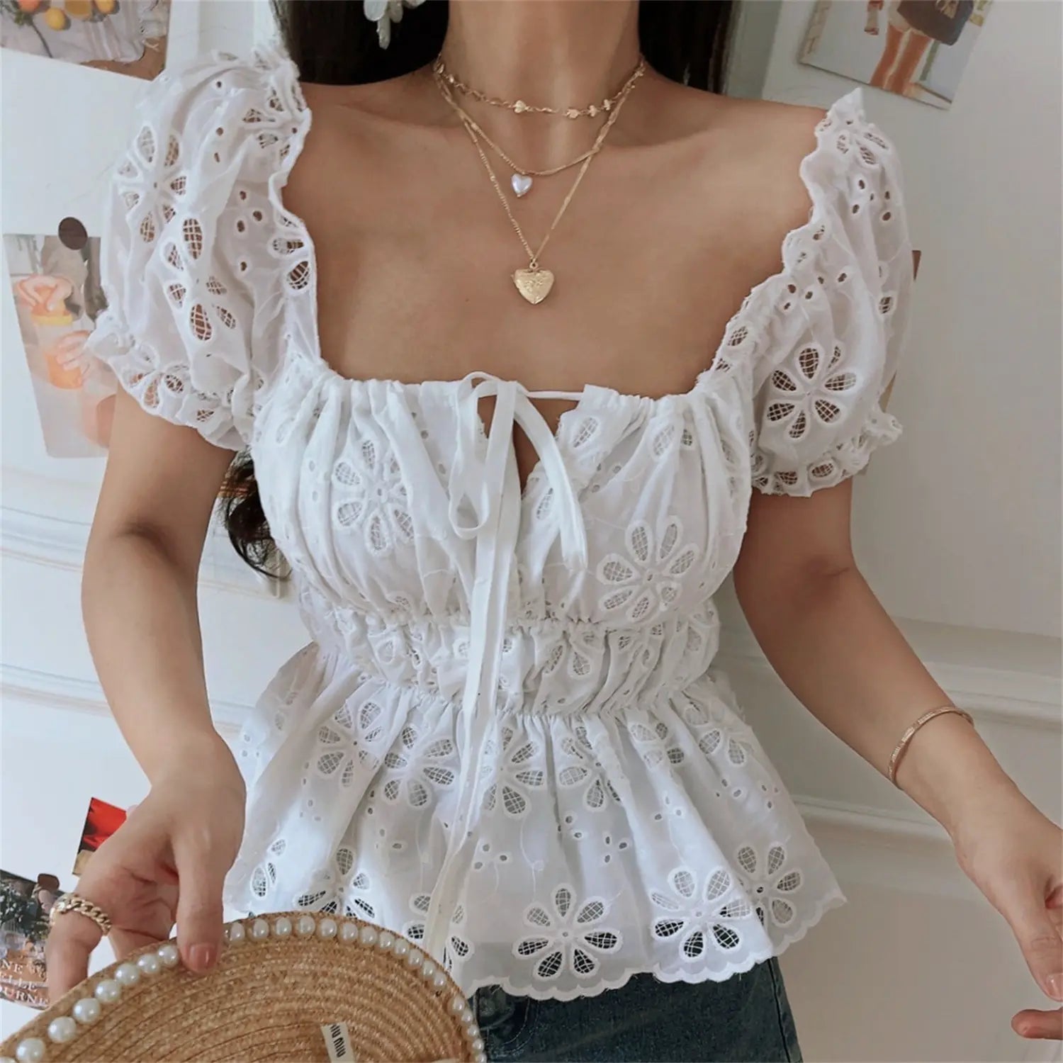 Front view lifestyle shot of the white embroidered off-shoulder peplum top