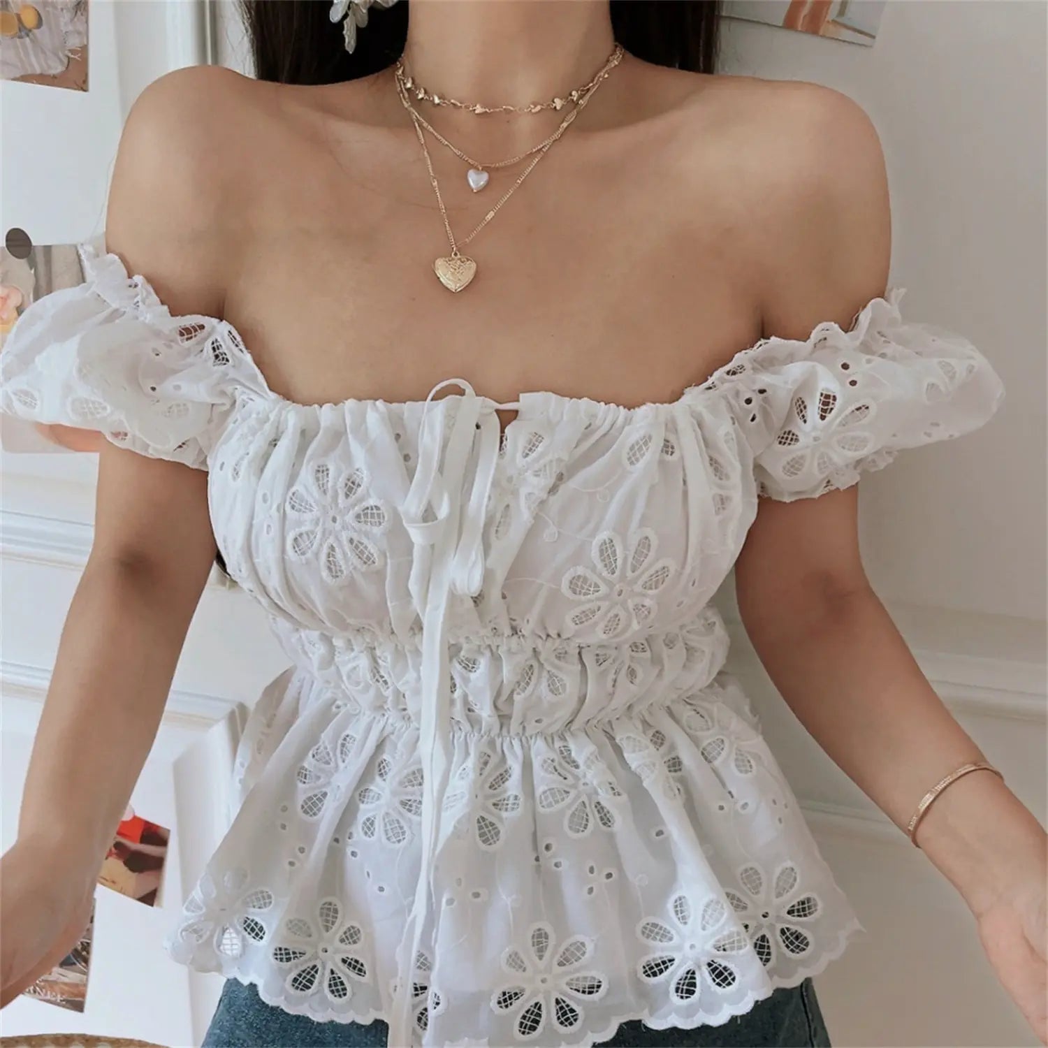 Square-neck lifestyle shot of model wearing the white embroidered peplum top