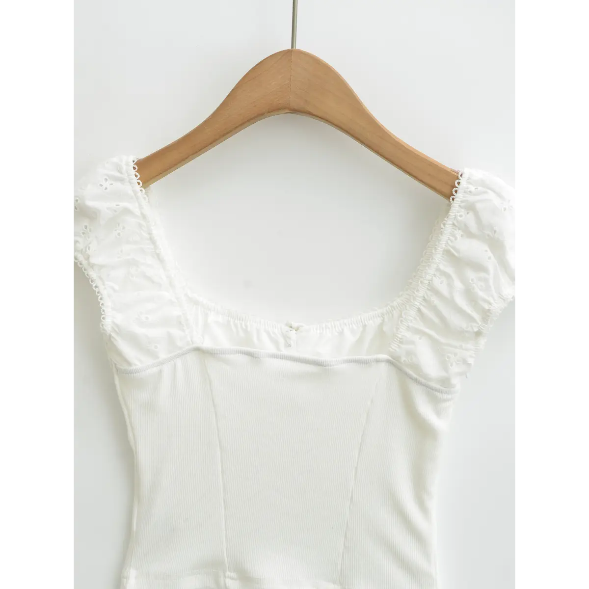  Full back view of white embroidered ribbed top, showing square neckline, puff sleeves and ribbed bodice.