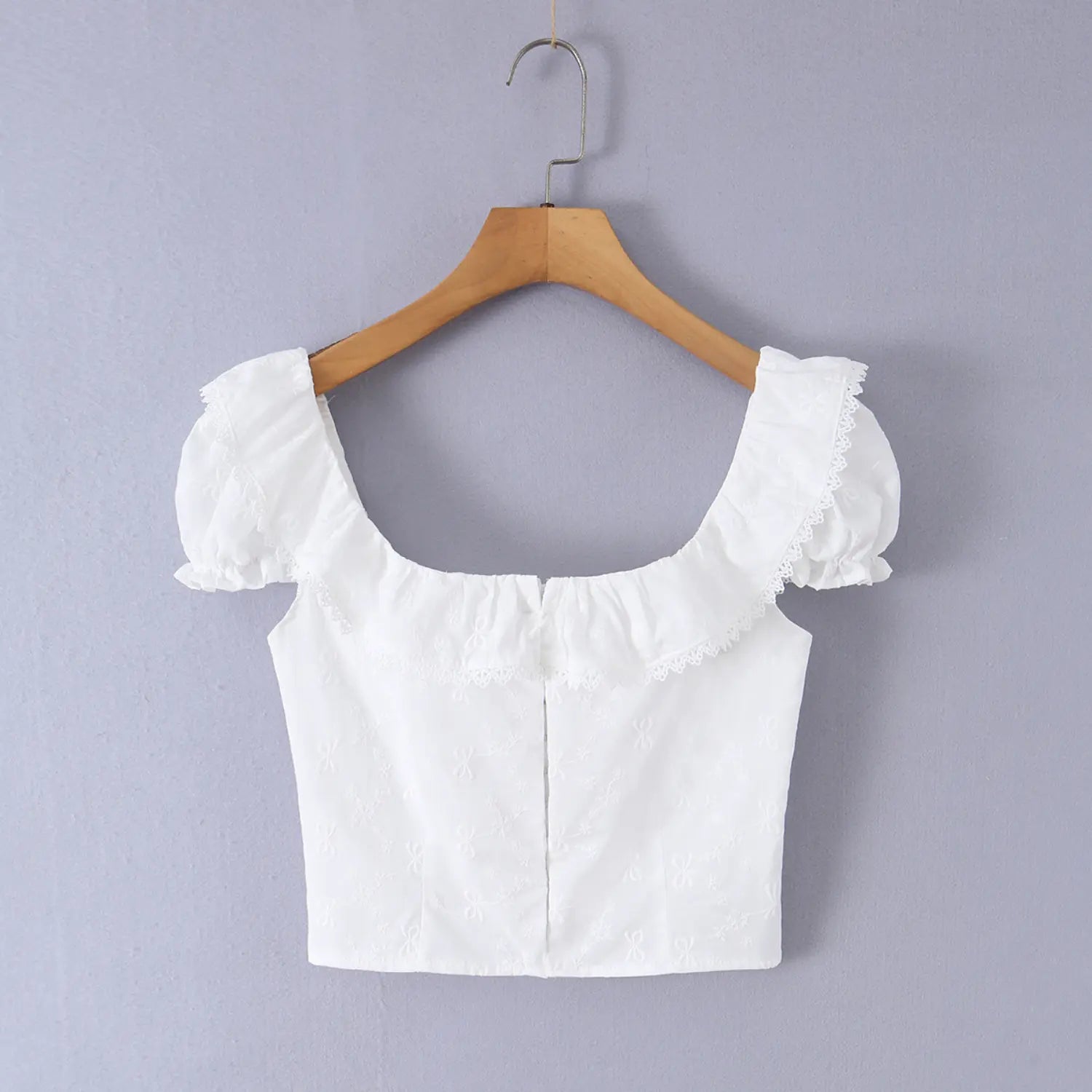 Close-up of the back smocking texture on the white embroidered camisole