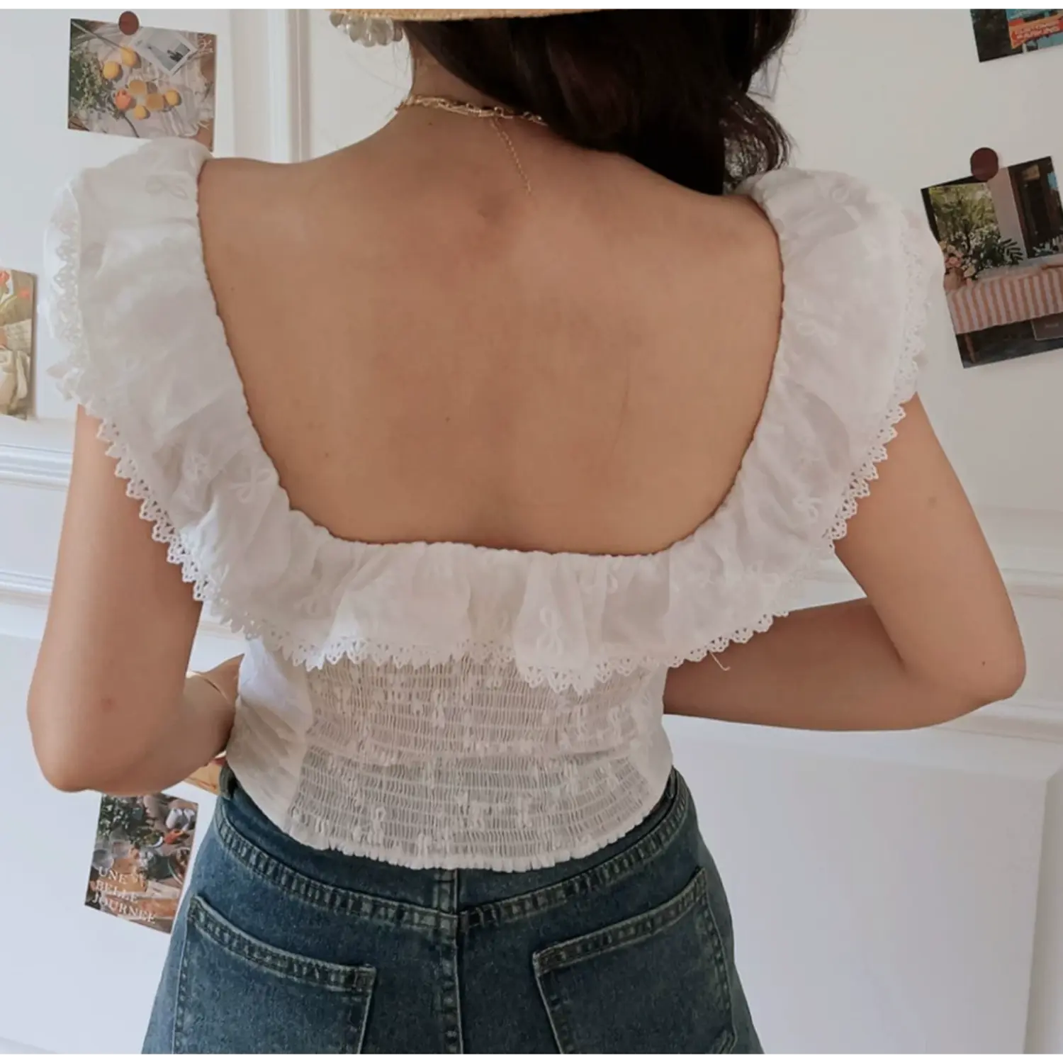Lifestyle back shot of model wearing the white embroidered square-neck lace-trimmed camisole
