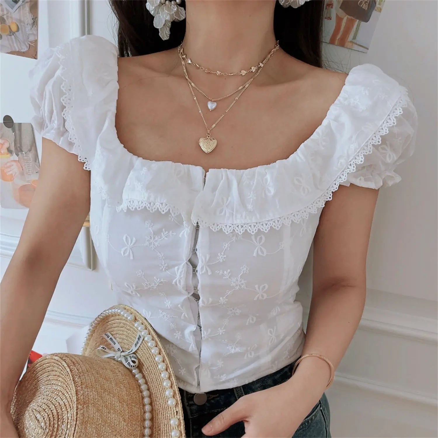 Close-up lifestyle shot of model wearing the white embroidered square-neck camisole