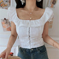 Close-up shot of model wearing the white embroidered square-neck camisole