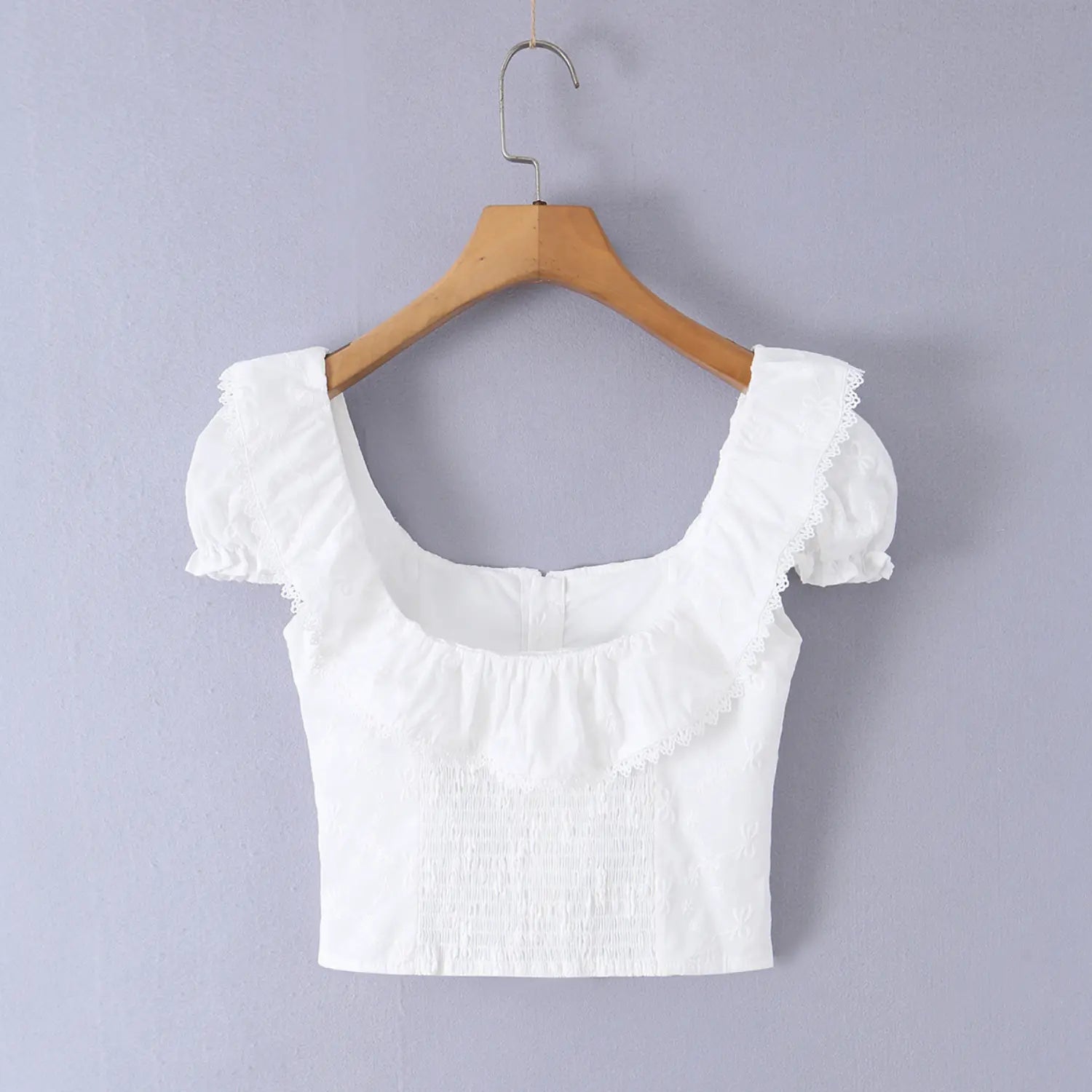 Full front view on white background of the white embroidered square-neck lace-trimmed camisole