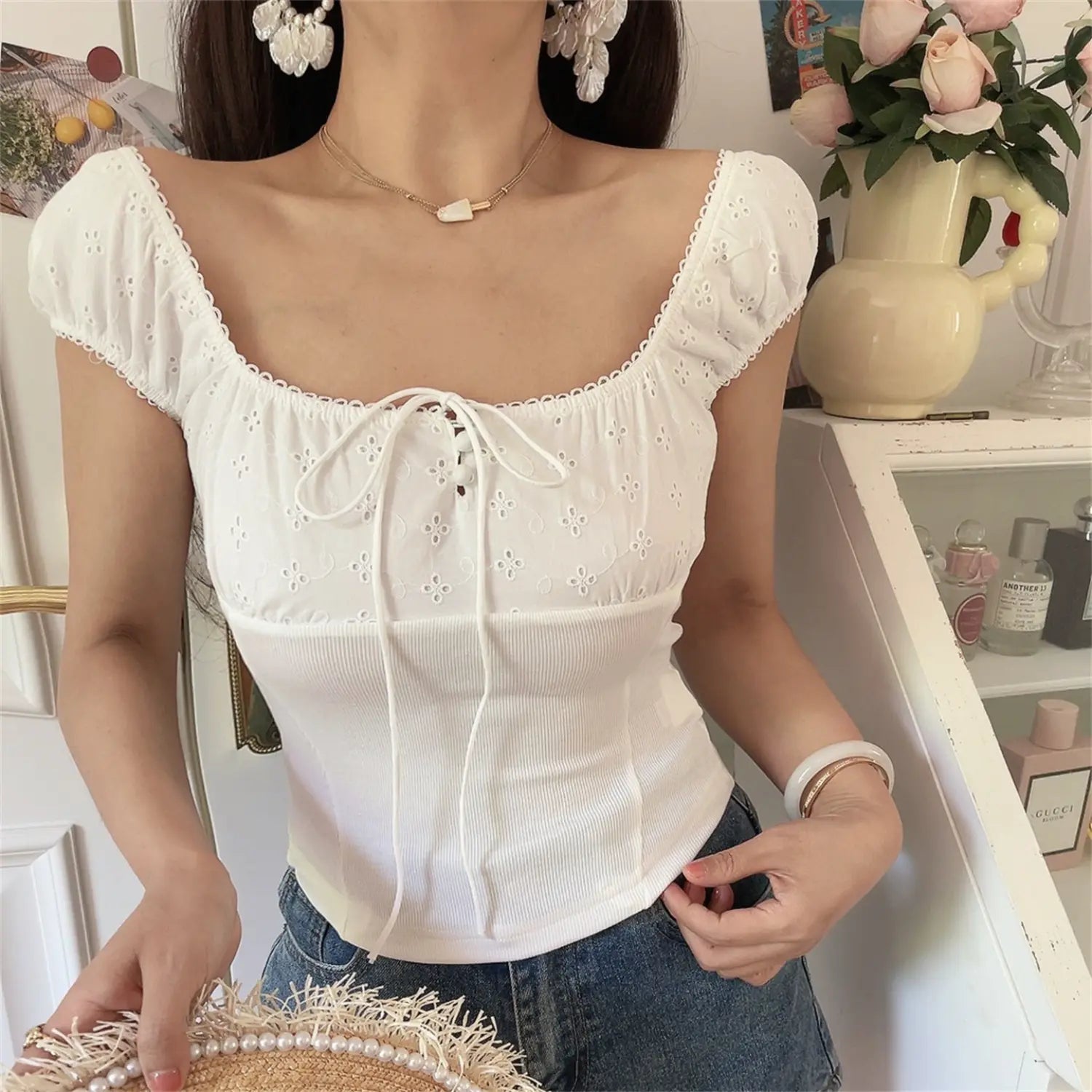 Front view lifestyle shot of the white embroidered square-neck top