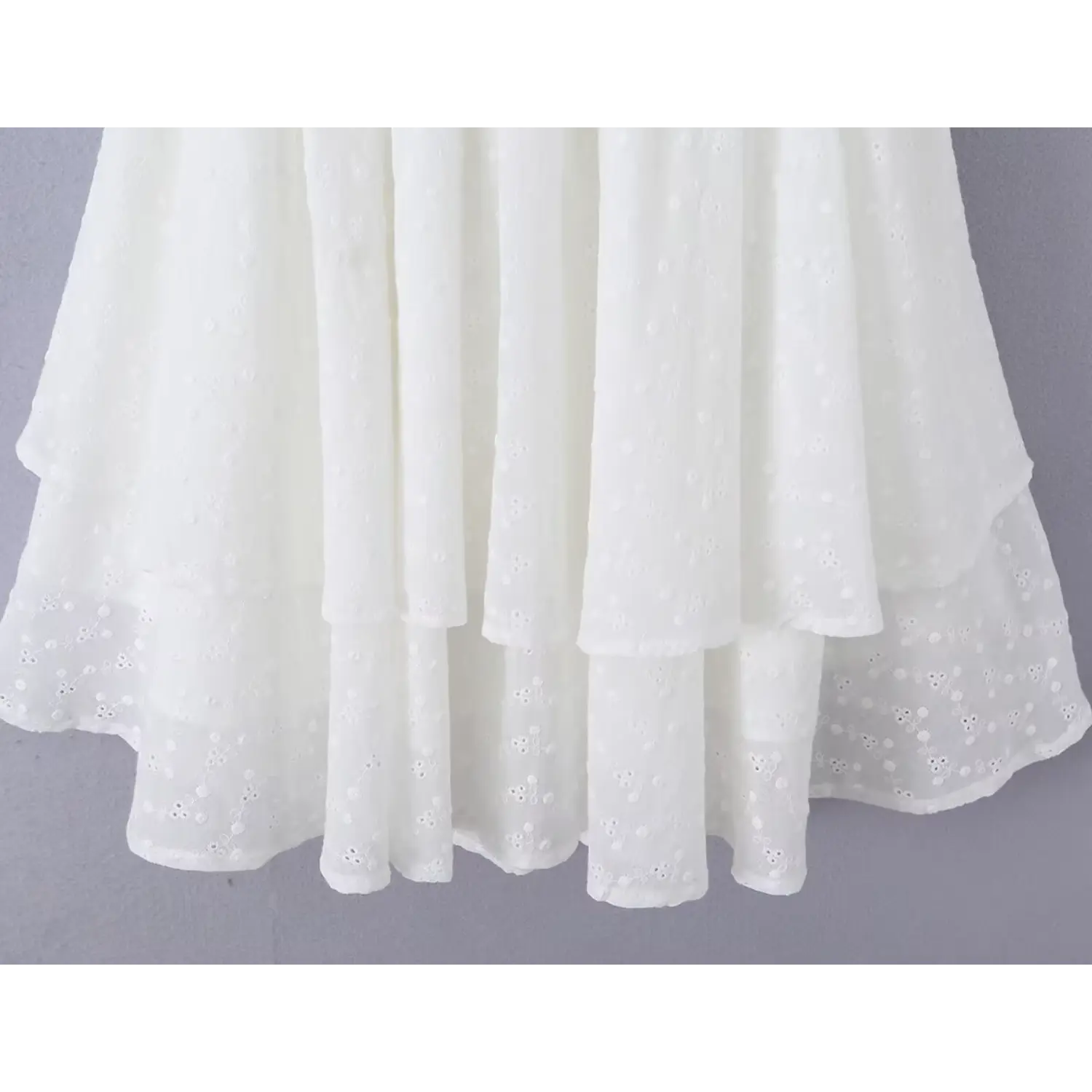 Close-up shot of the tiered ruffle skirt hem, showing the eyelet lace texture and layered design