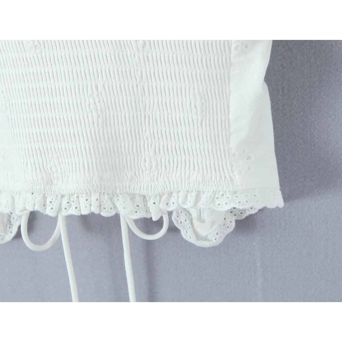 Back view showing full smocked panel, lace-trimmed hem, and adjustable spaghetti straps.