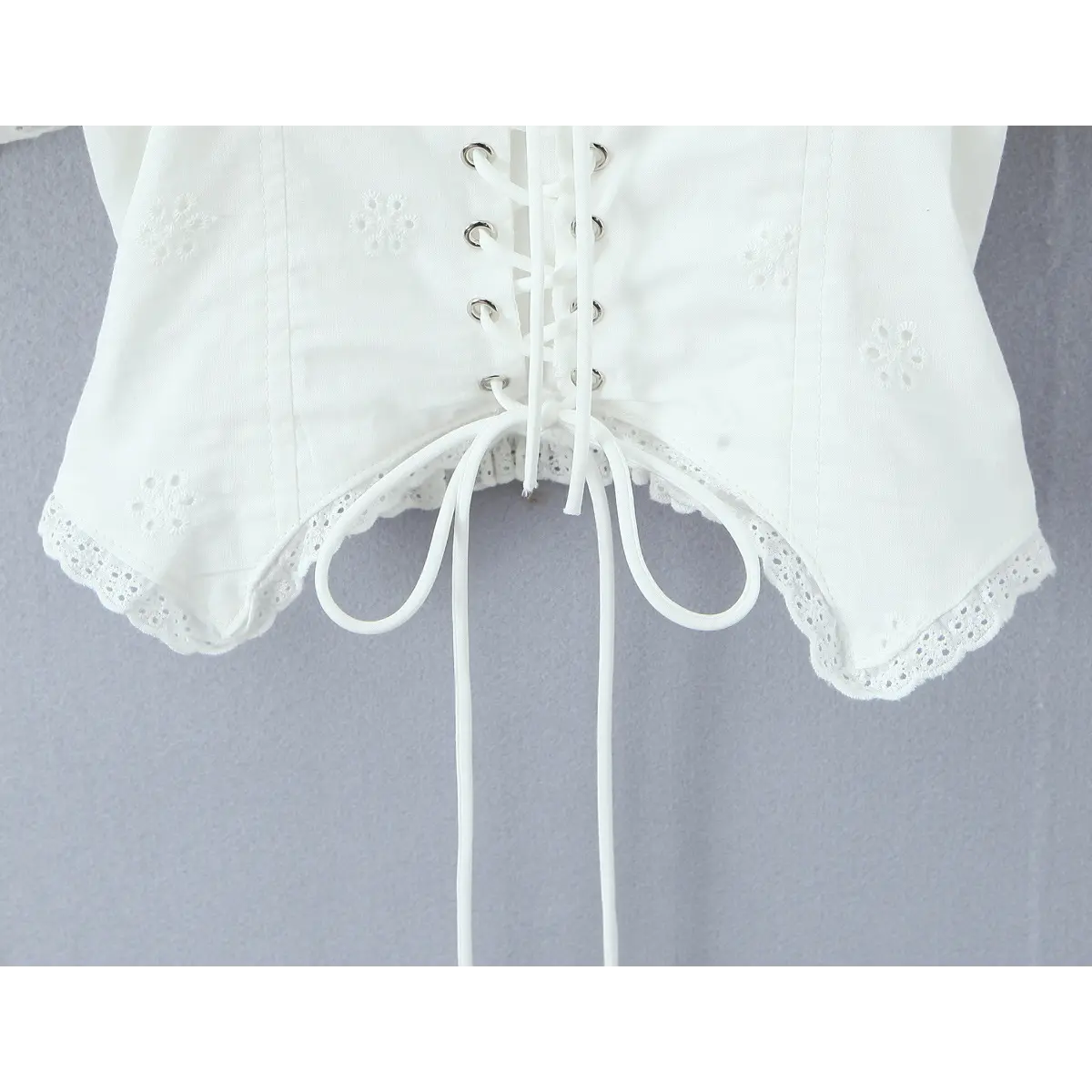 Close-up of scalloped lace-trimmed hem and adjustable drawstring ties.