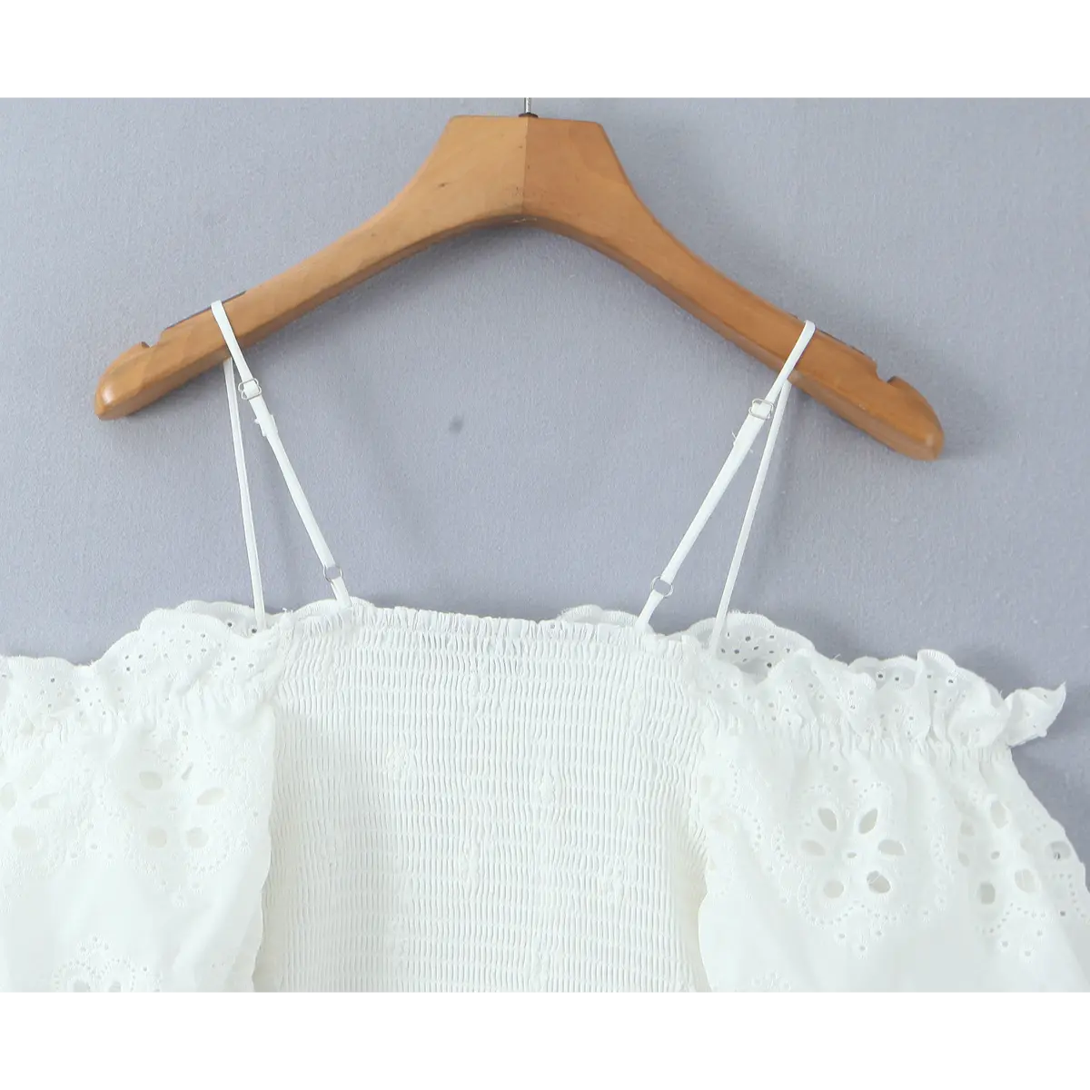 Close-up of adjustable straps, ruffled eyelet neckline, and smocked upper back.