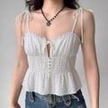Lifestyle shot of model wearing the white eyelet peplum cami top with jeans, showing the tiered silhouette and sweetheart neckline
