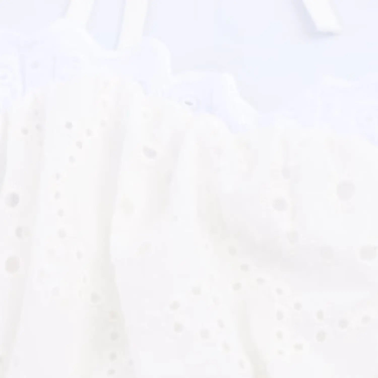 Close-up of the scalloped lace trim along the sweetheart neckline of the white cami