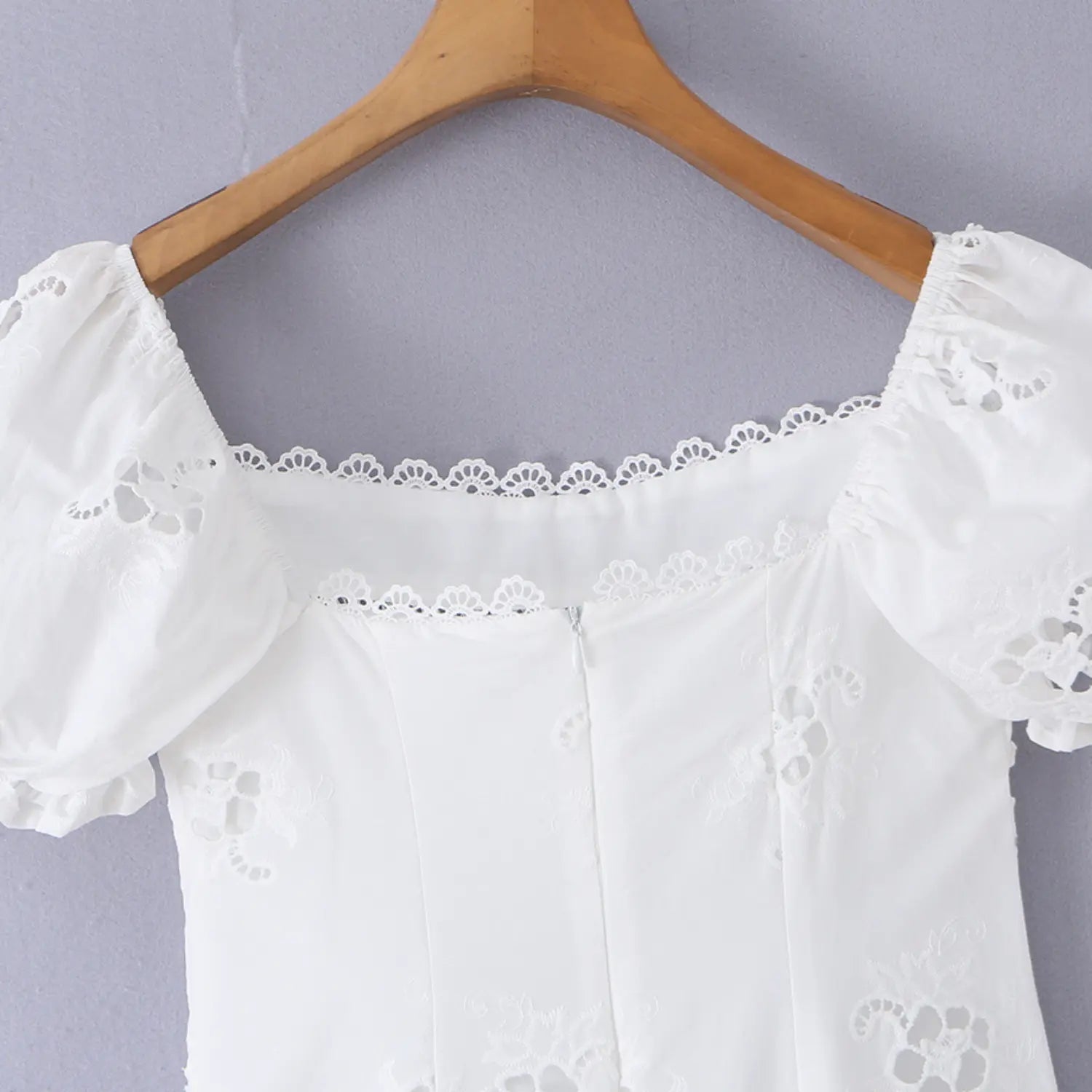Close-up of the invisible back zipper on the white eyelet puff-sleeve dress