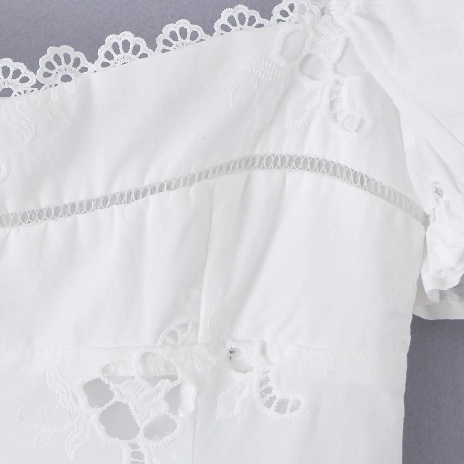 Close-up of the ladder lace insert at the bustline of the white eyelet dress