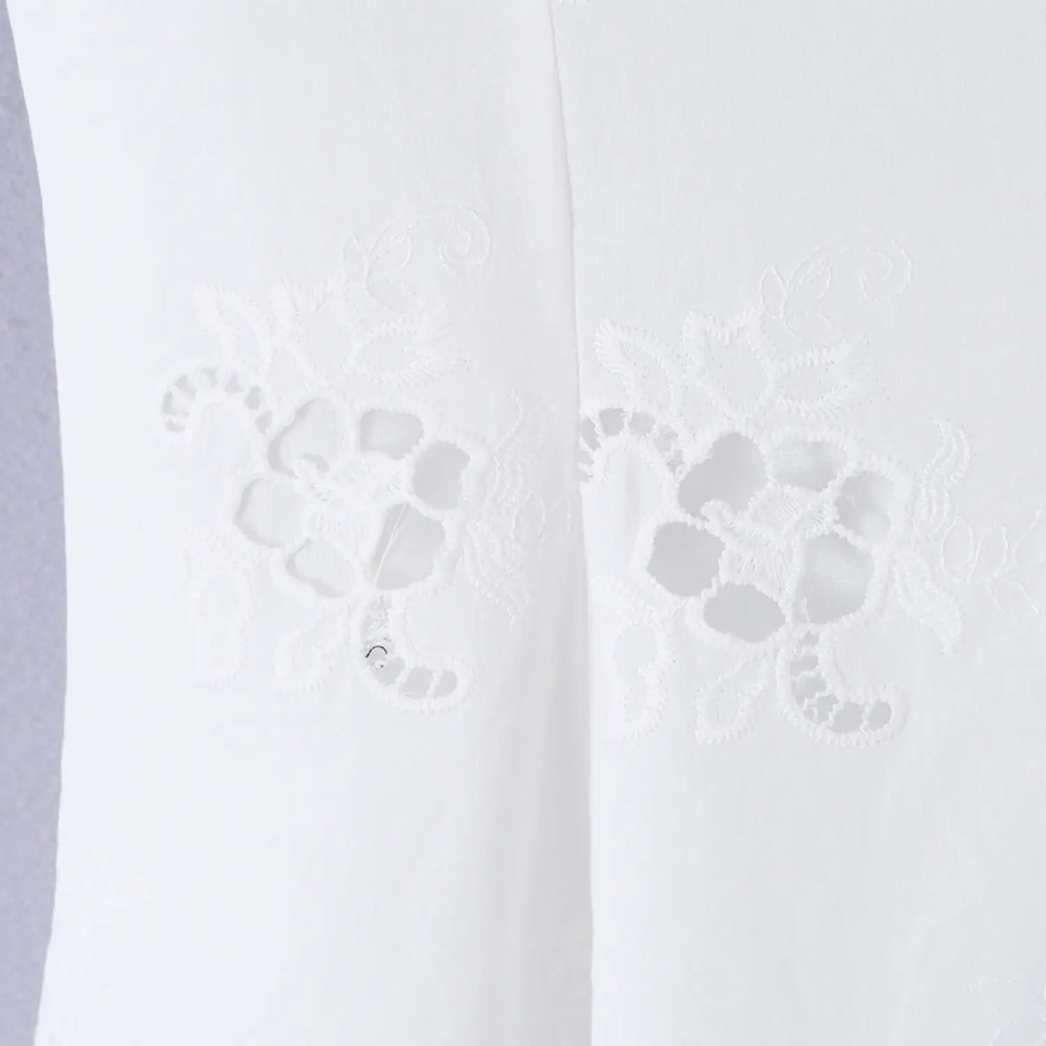 Close-up of the embroidered eyelet floral motifs on the front bodice