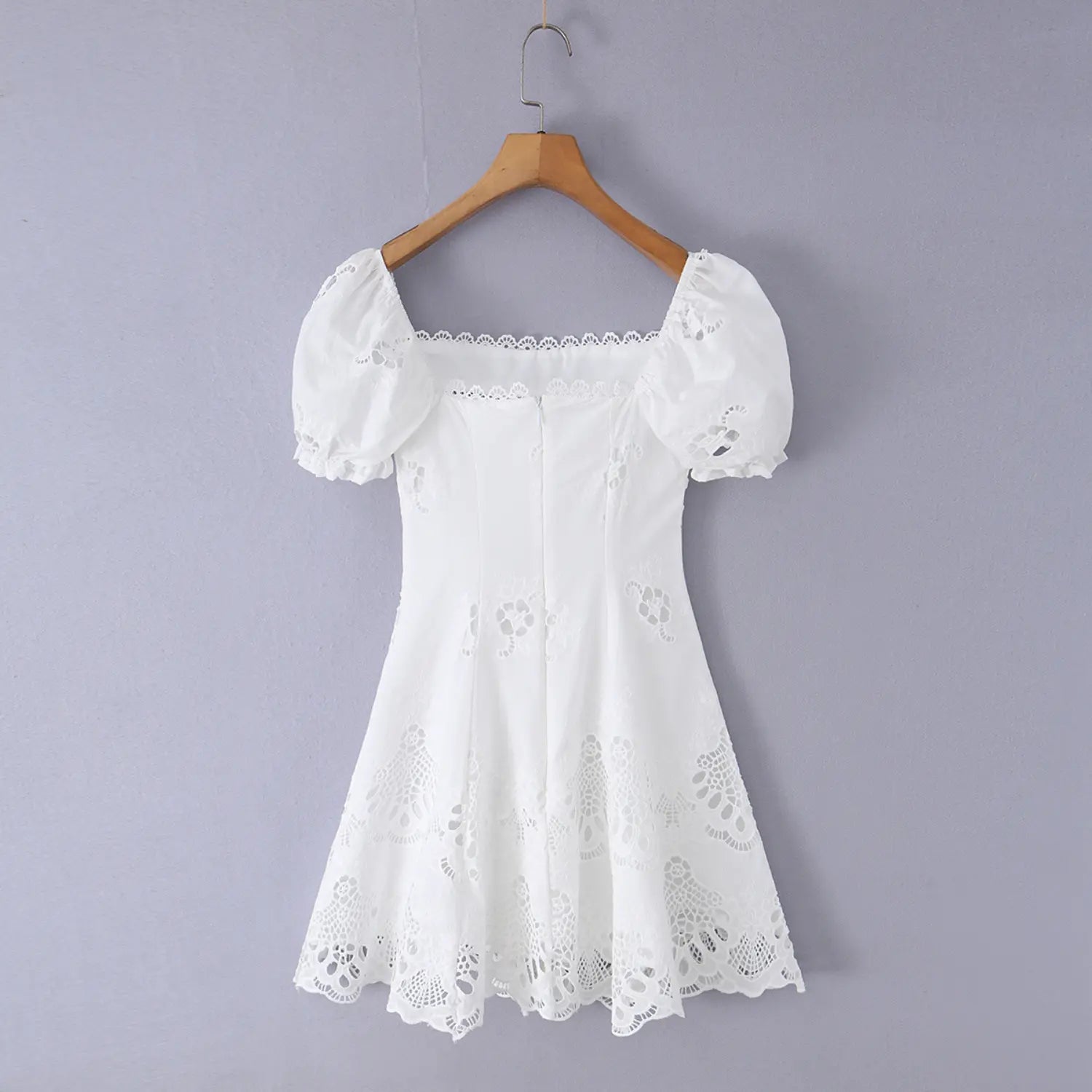 Full back view on white background of the white eyelet dress with puff sleeves