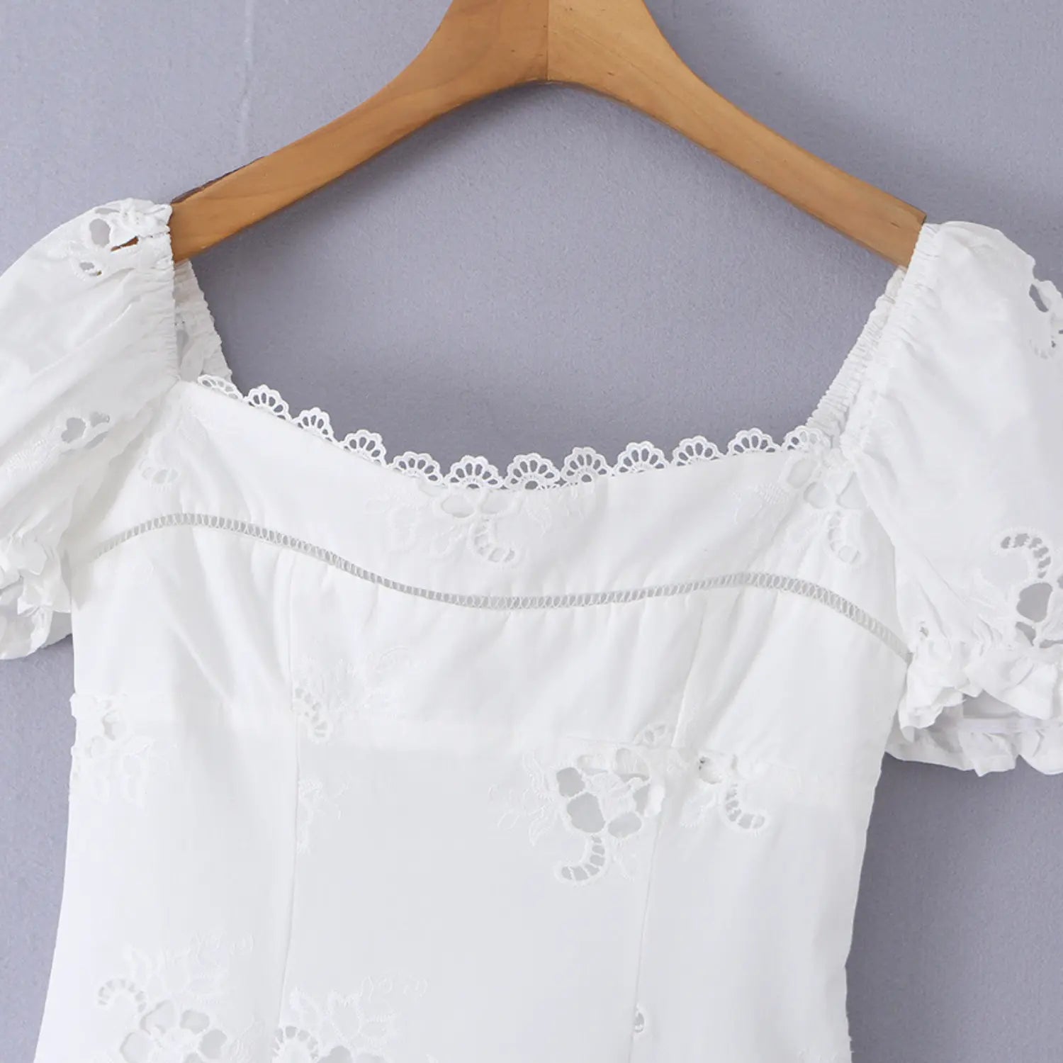 Lifestyle shot of model wearing the white eyelet puff-sleeve dress, showing the full silhouette