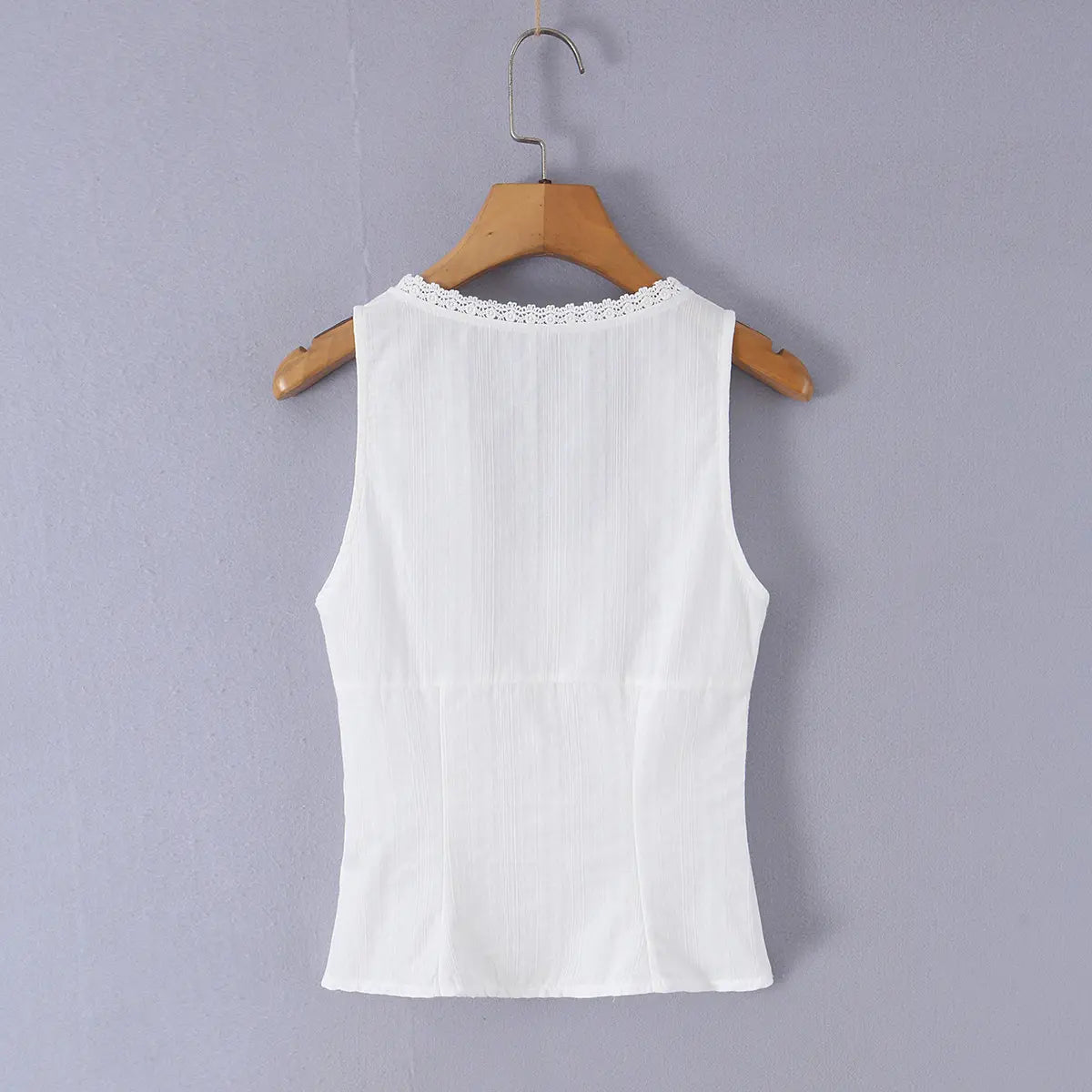 Back view of a white ribbed bustier tank top hung on a wooden hanger, showing the smooth back, lace-trimmed neckline, and fitted silhouette.
